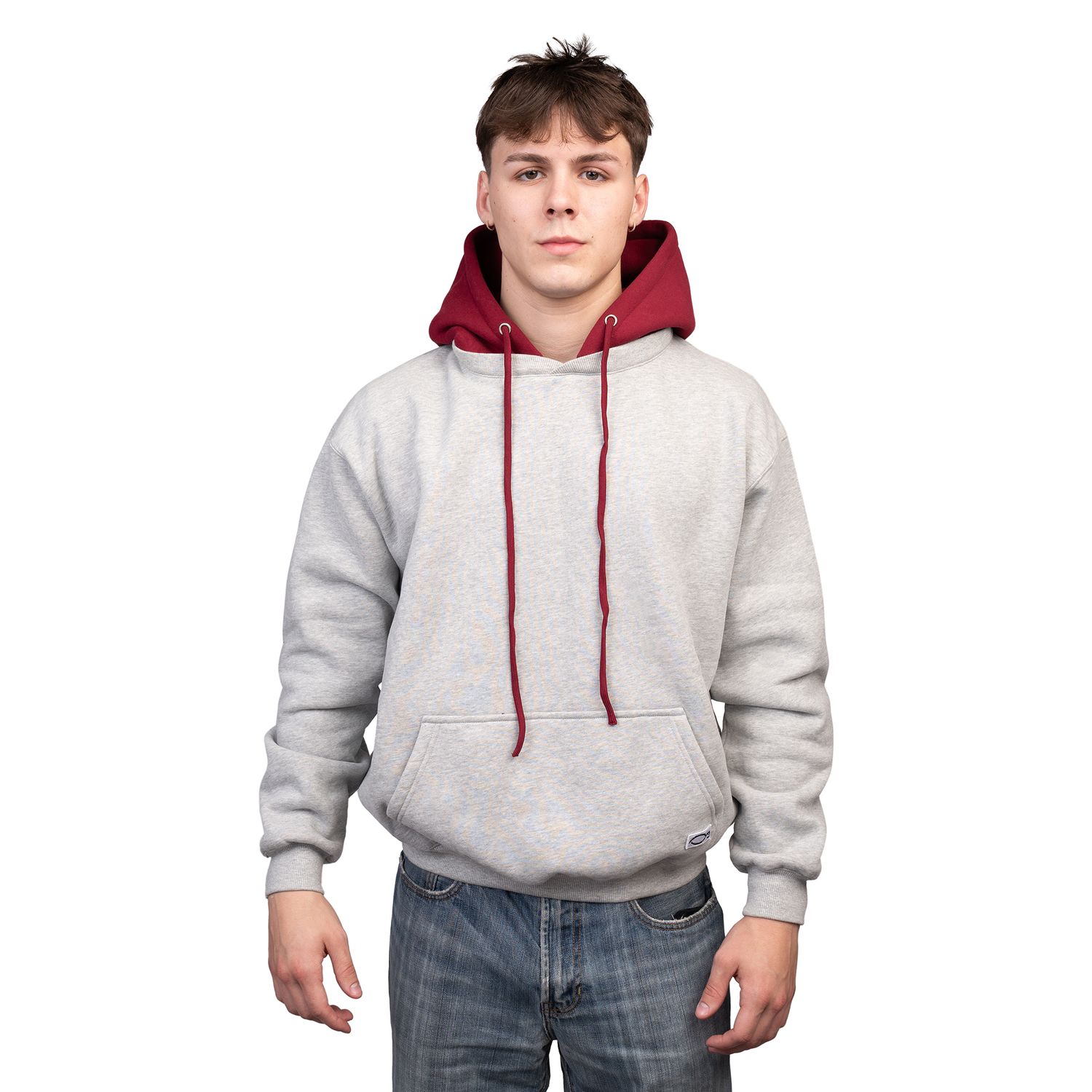 Person wearing a gray hoodie with burgundy drawstrings and blue jeans in a casual pose against white background.
