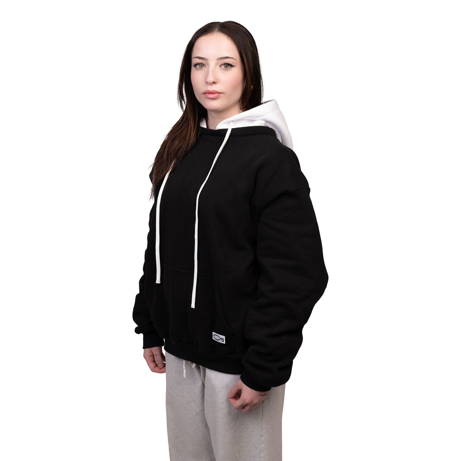 Cozy black and white two-tone sherpa hoodie jacket shown with gray sweatpants in casual winter style.