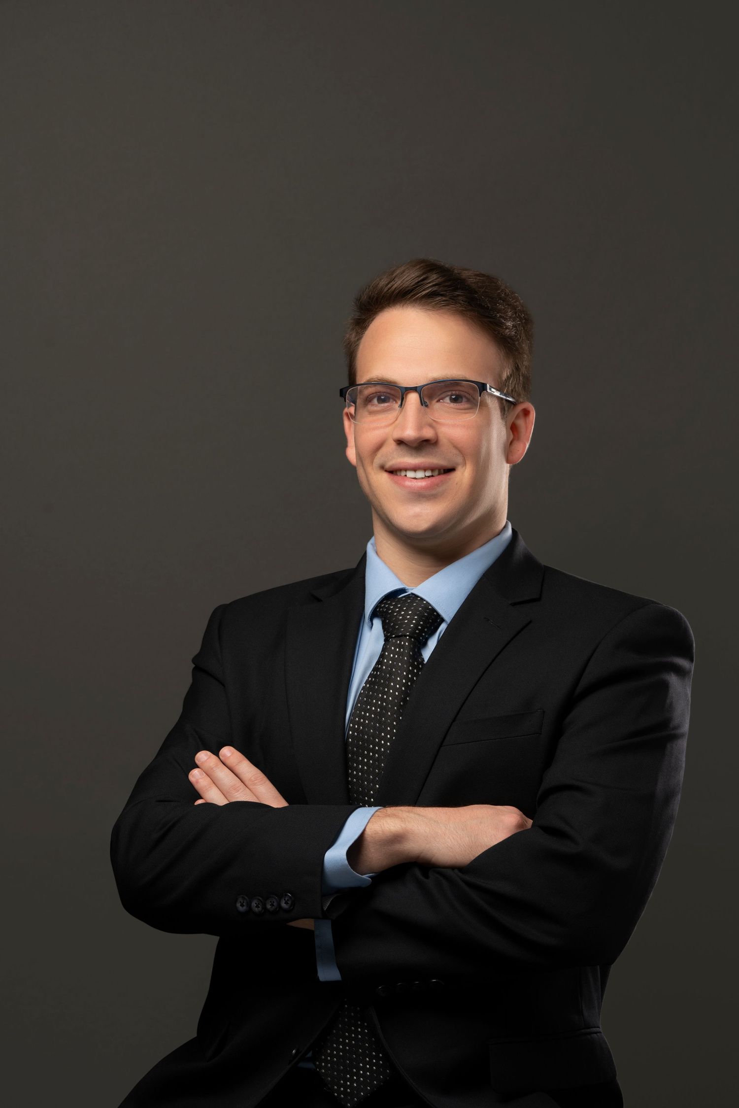 Professional business portrait series showing figure in dark suit and blue tie against gray background in various poses.