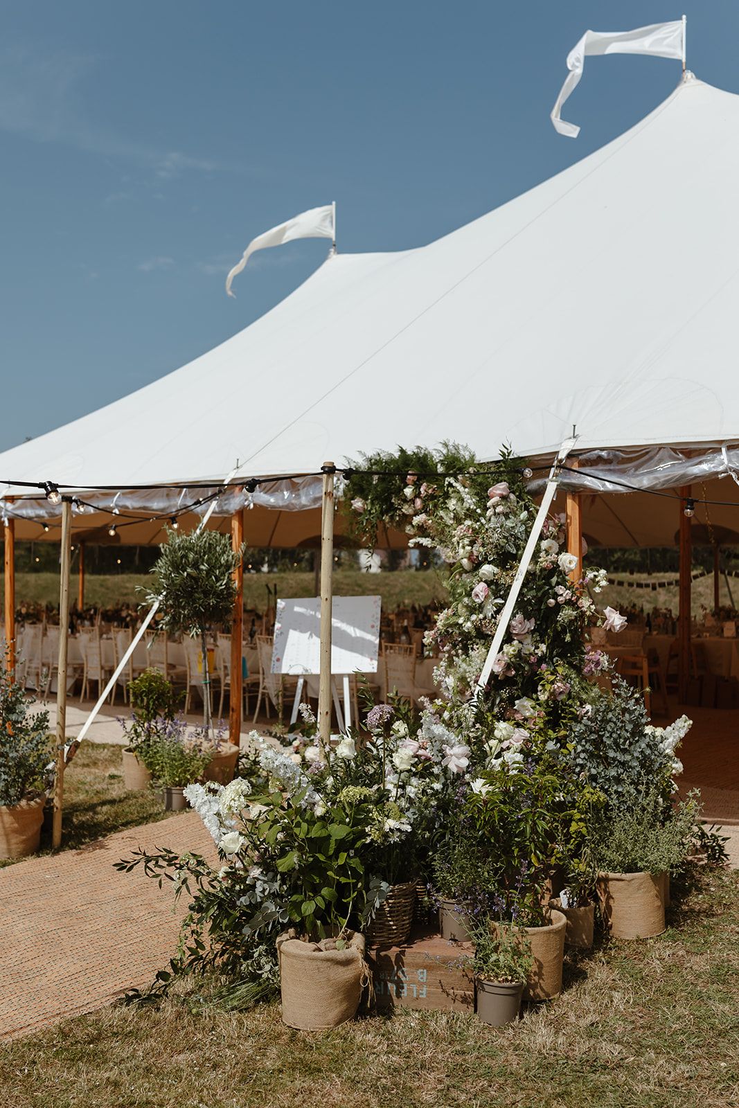 Luxury Marquee wedding in Guernsey. Flowers decorate the tent at family home.
