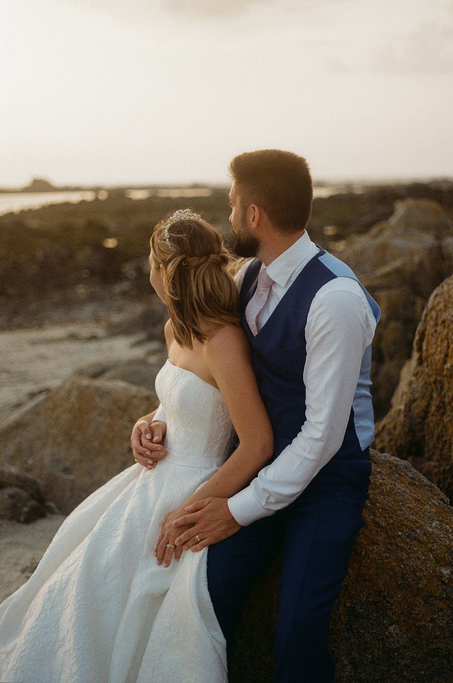 Couple look into the distance at their beach wedding.