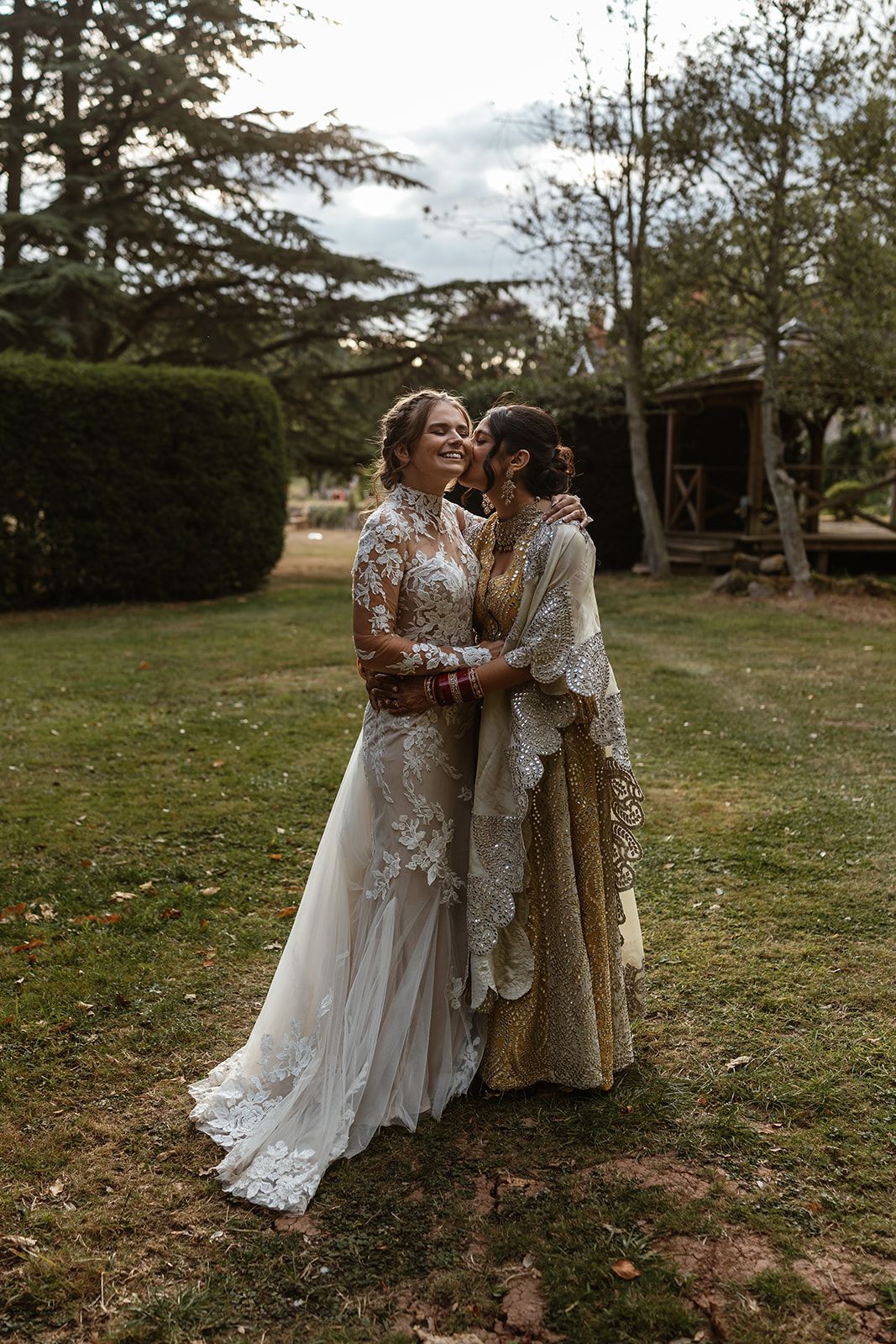 Same sex couple kiss at Brinsop Court Manor House and Barn, Herefordshire. Fusion wedding.