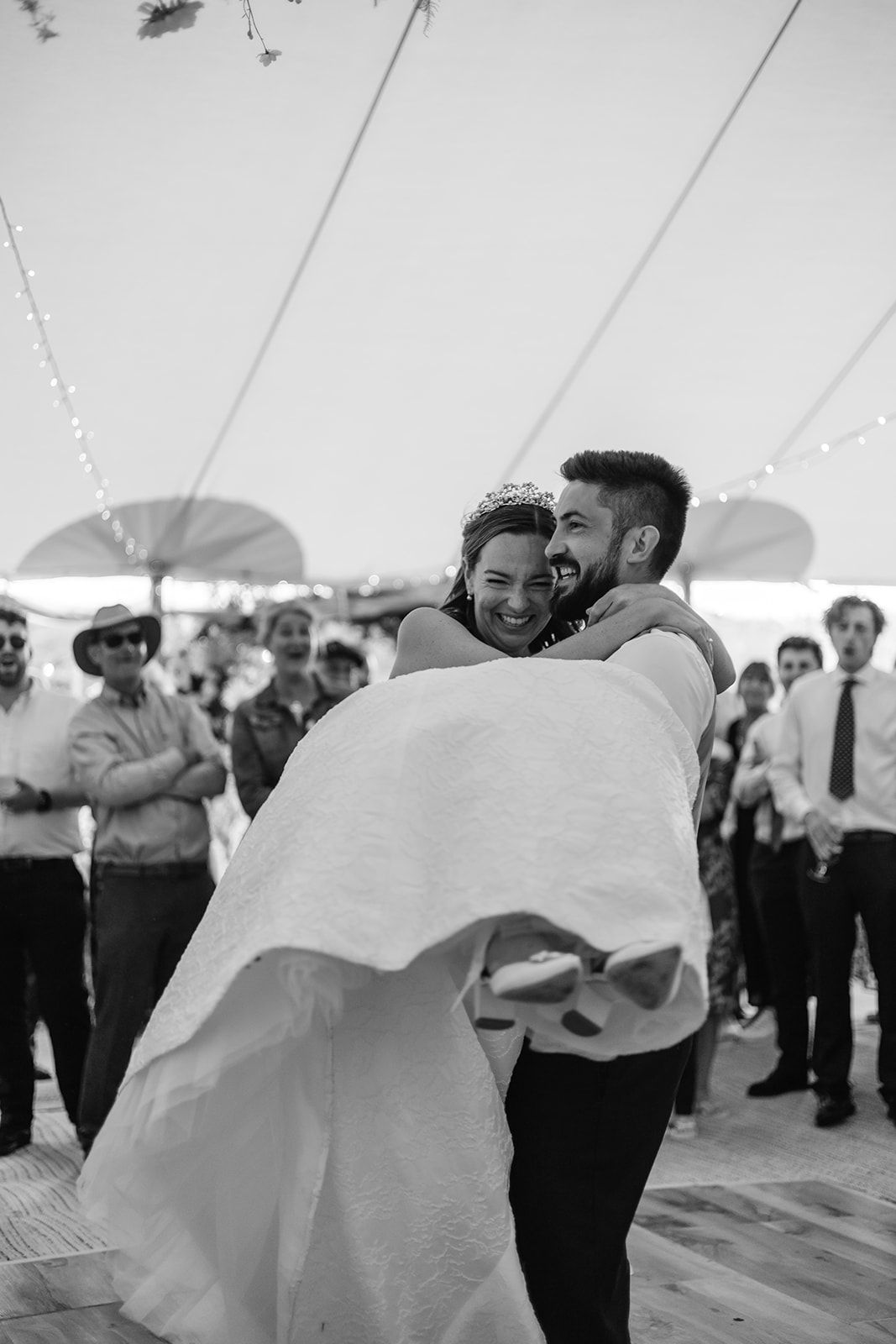 Bride is spun around by groom at family marquee at Guernsey wedding.