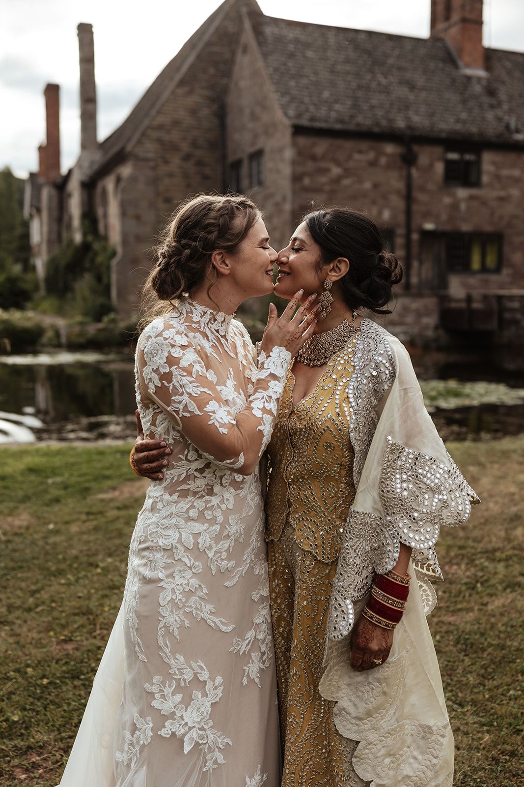 Same sex couple kiss at Brinsop Court Manor House and Barn, Herefordshire. Fusion wedding.