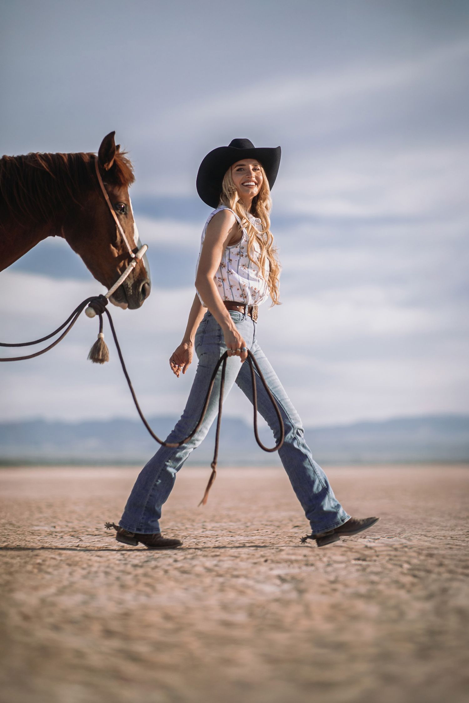 Master Hatters of Texas 1968 Hat Campaign image of a cowgirl and a Mustang horse crossing a dry lakebed. Lifestyle Product Photography.