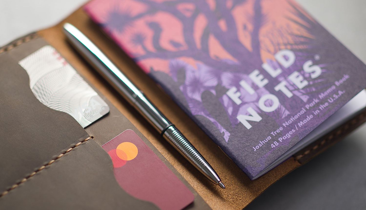 Fisher Space Pen - Bullet Pen set in a leather journal with a Field Notes journal. Product Lifestyle photography.