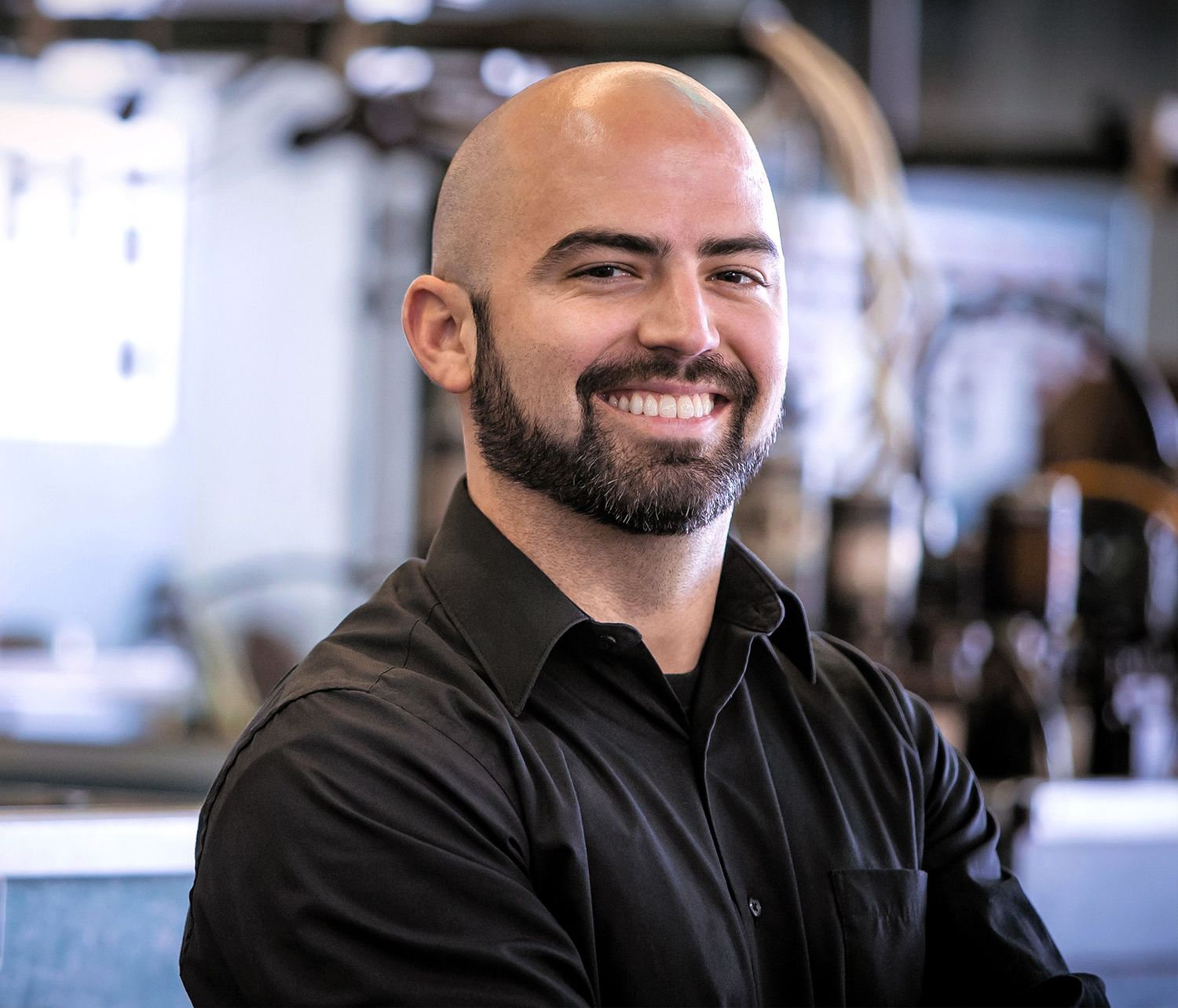 Professional portrait series showing expressions of person in black shirt against light background.
