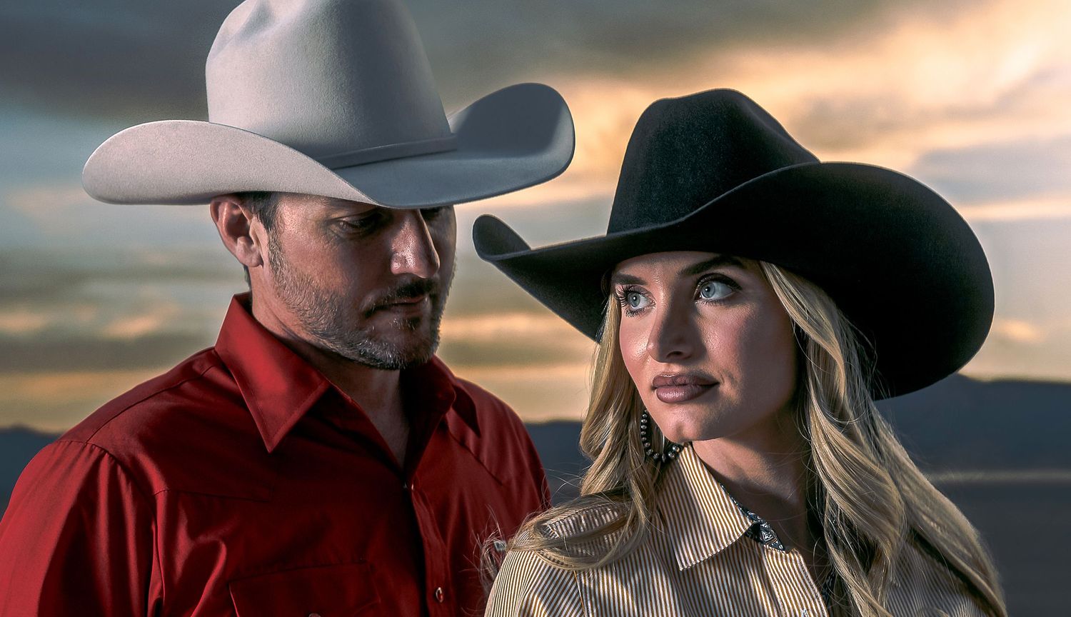 Romantic couple in western attire sharing intimate moments at sunset in a desert landscape. Master Hatters of Texas 1968 Hat Campaign Image.