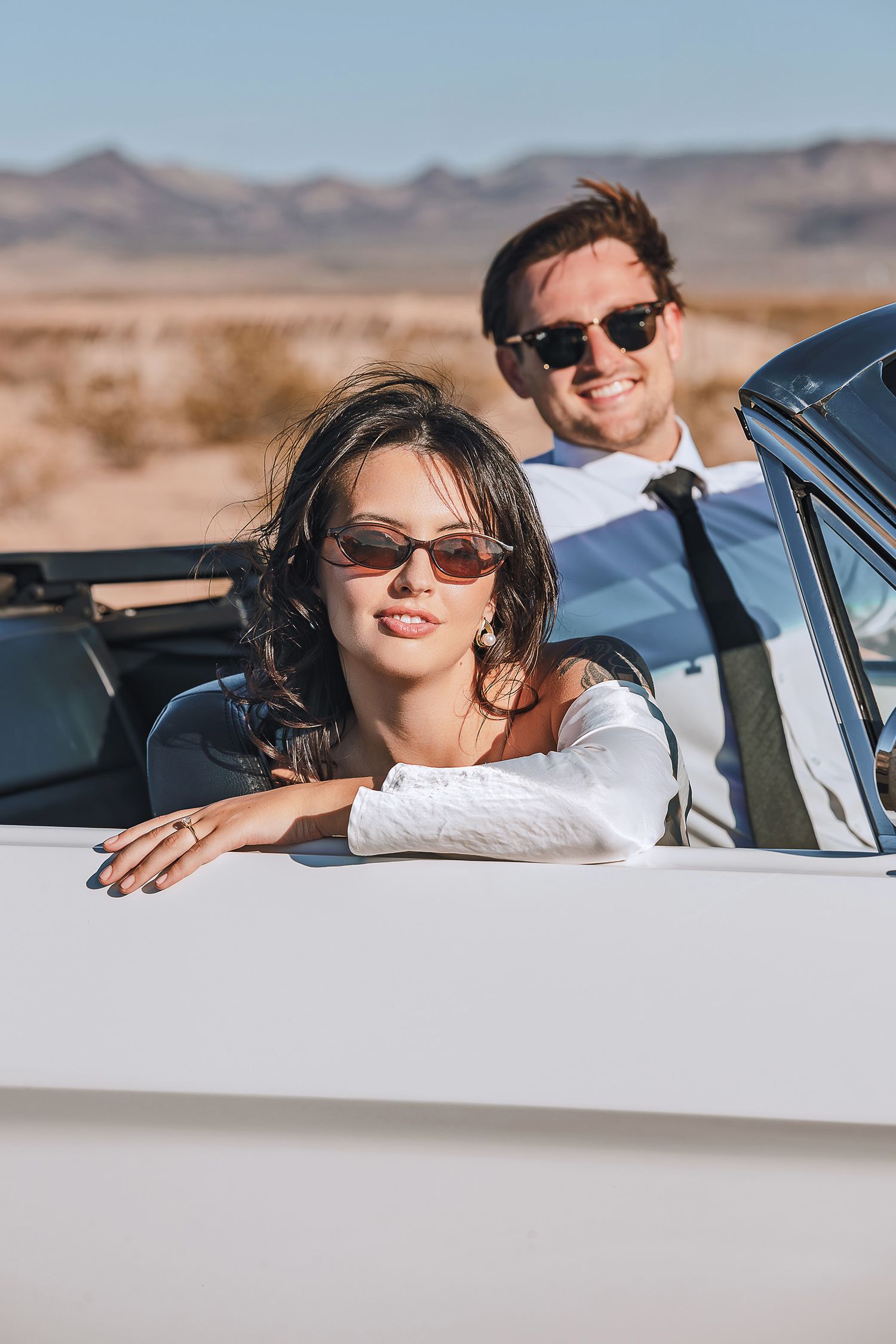 Editorial Fashion Lifestyle photography. A couple posing in a convertible car in the open desert.