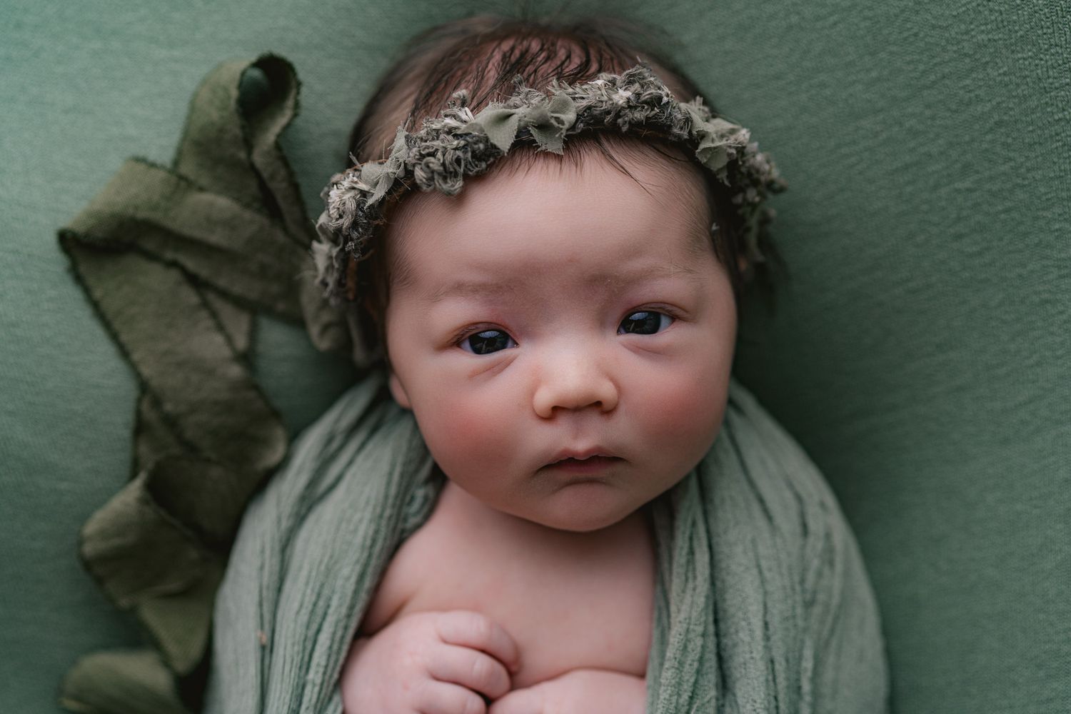 Awake baby in green. Madison, WI baby pictures.