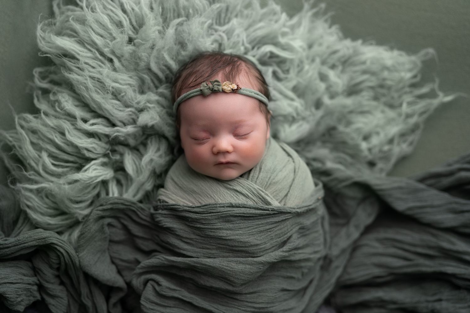 Baby asleep in green. Madison, WI baby pictures.