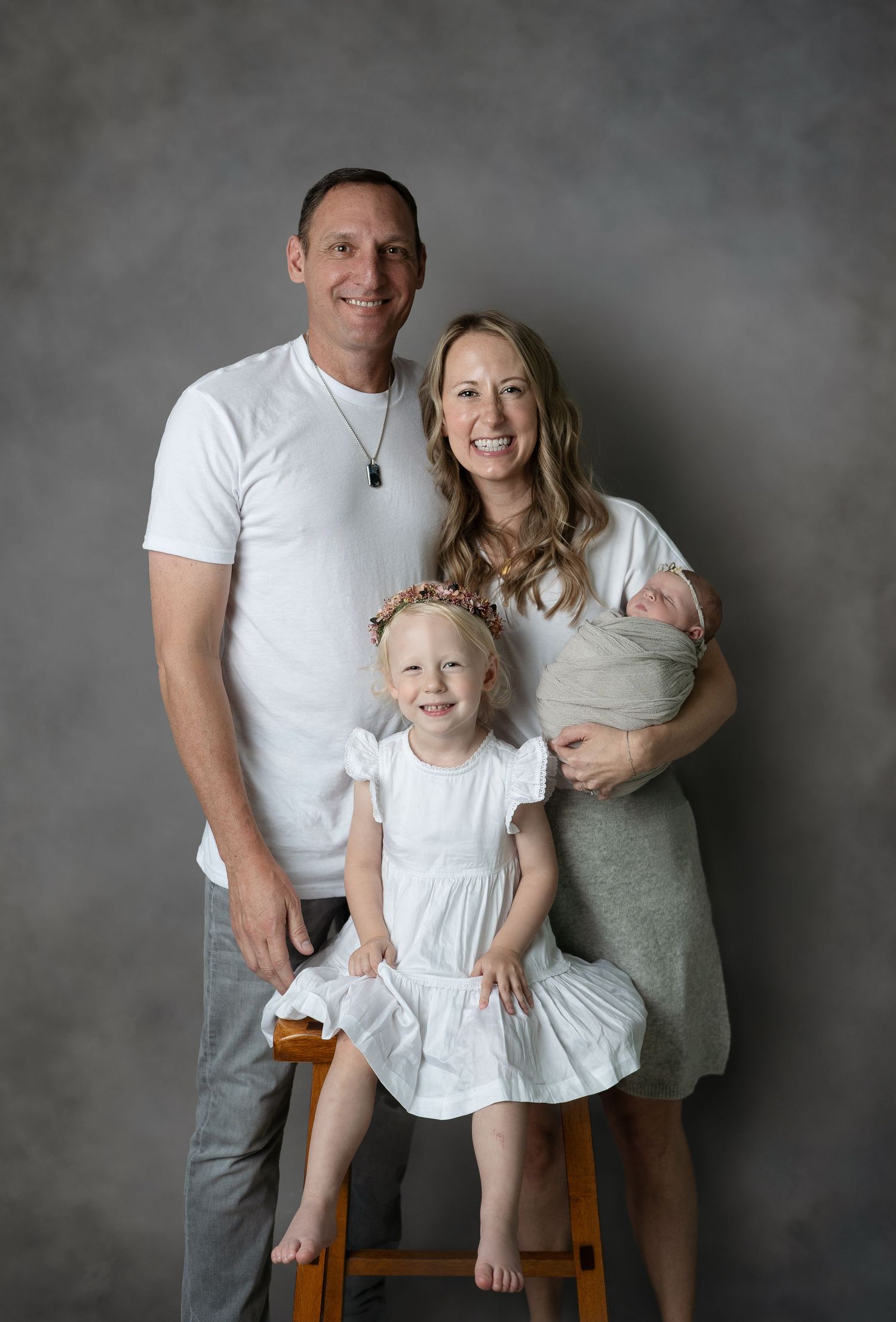 Sweet family on classic grey background. Hatched Newborn and Family Photography