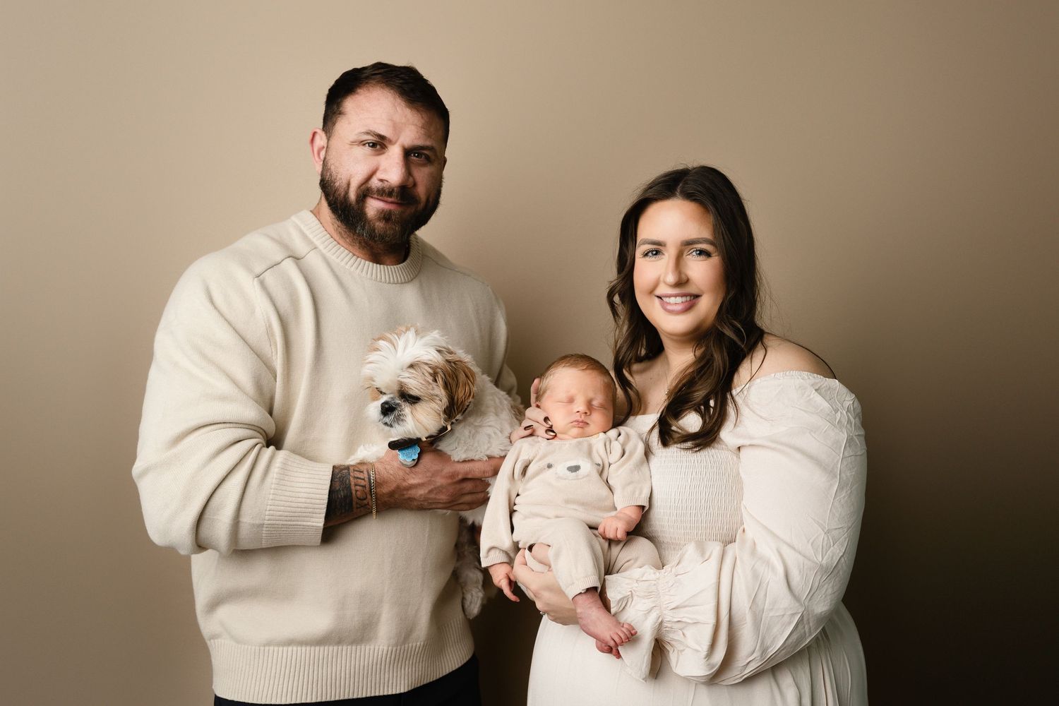 Baby snuggled in mother's arms. with father and dog brother in far west Madison, wi newborn photography