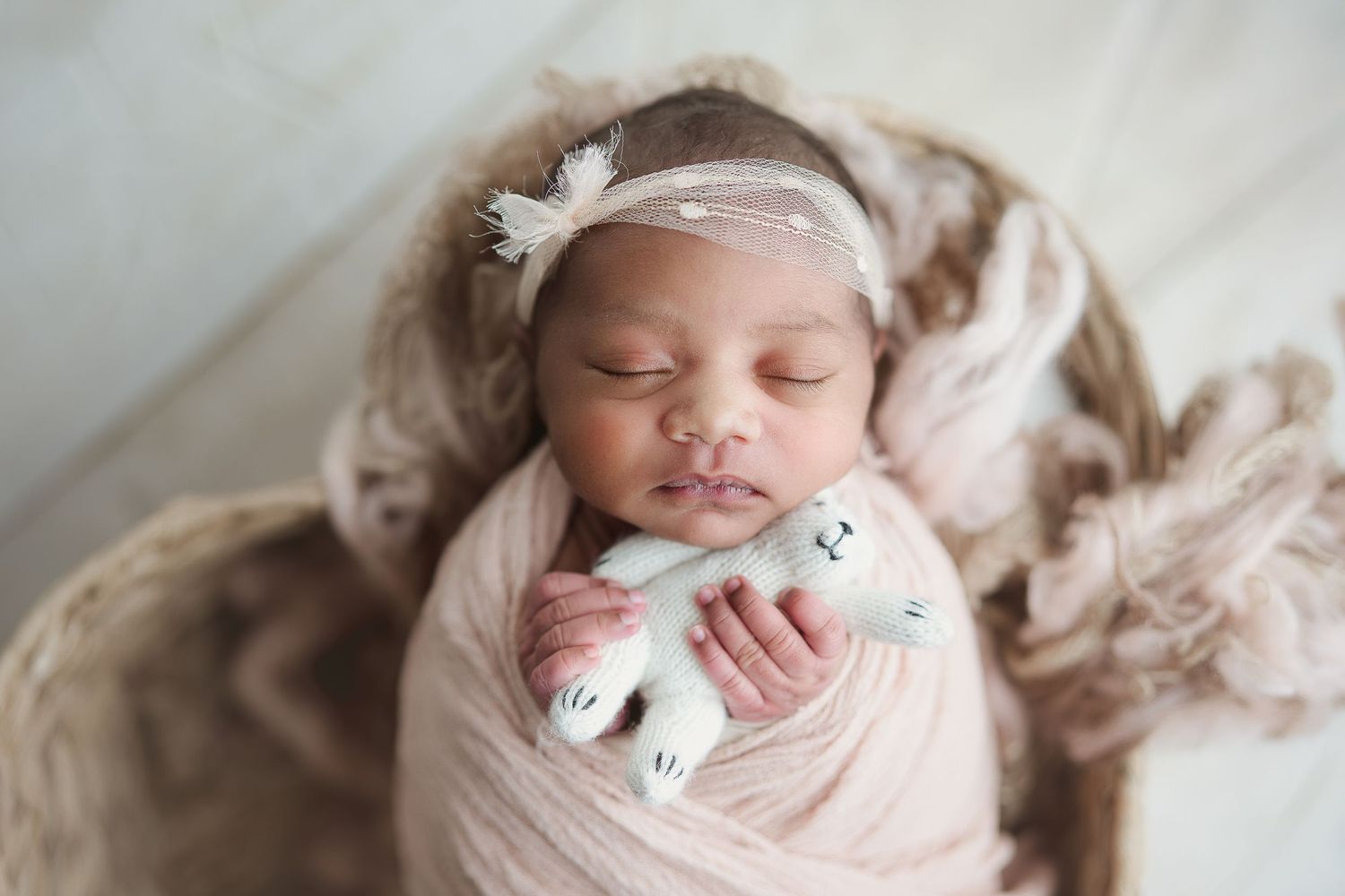 Newborn wrapped in pink, laying in a heart shaped basket. Hatched Newborns. Madison, Mount Horeb, Verona, Middleton, Sun Prairie, Wisconsin