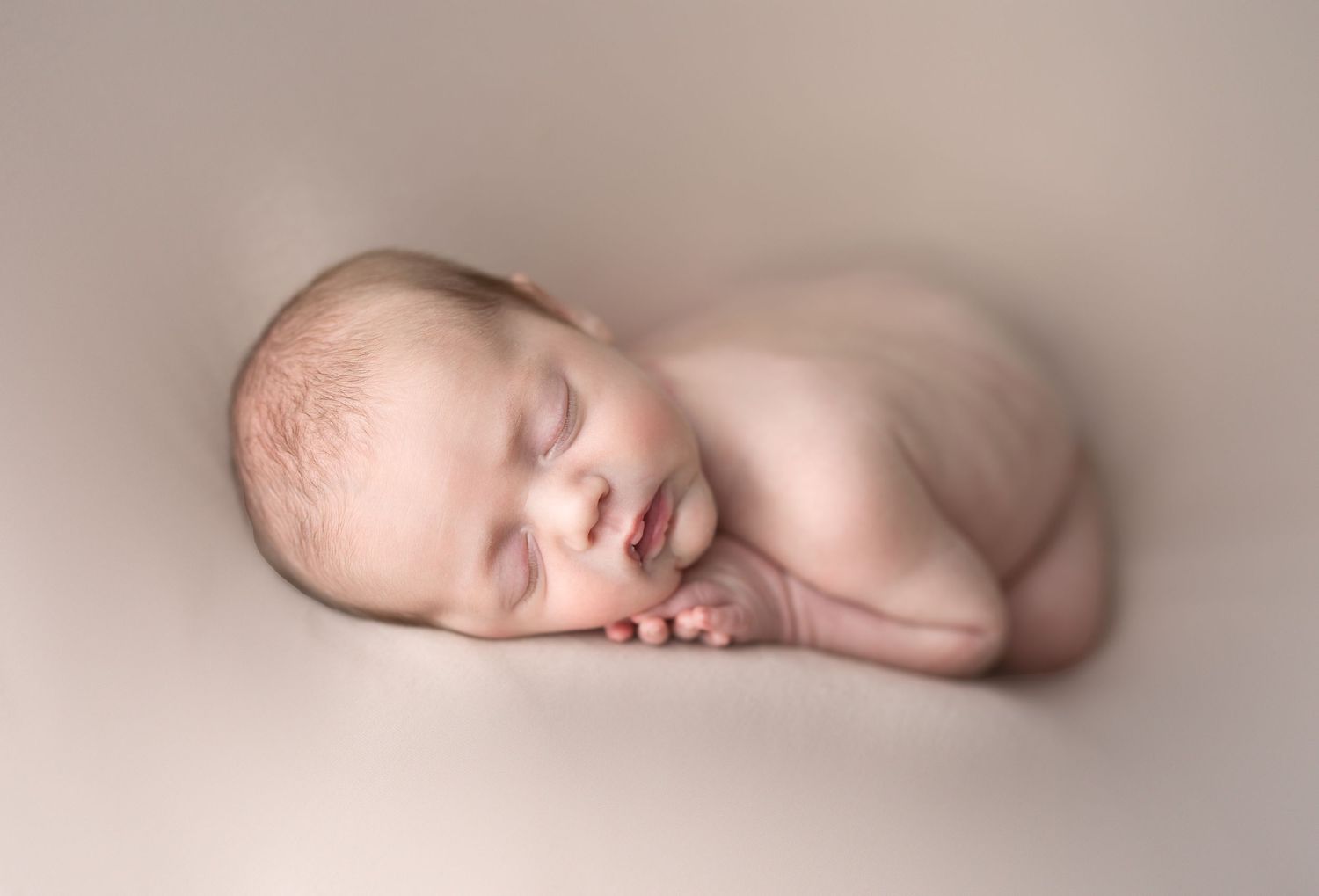 Baby laying on nude backdrop. Newborn photo. Hatched Newborns. Madison, Mount Horeb, Verona, Middleton, Wisconsin.