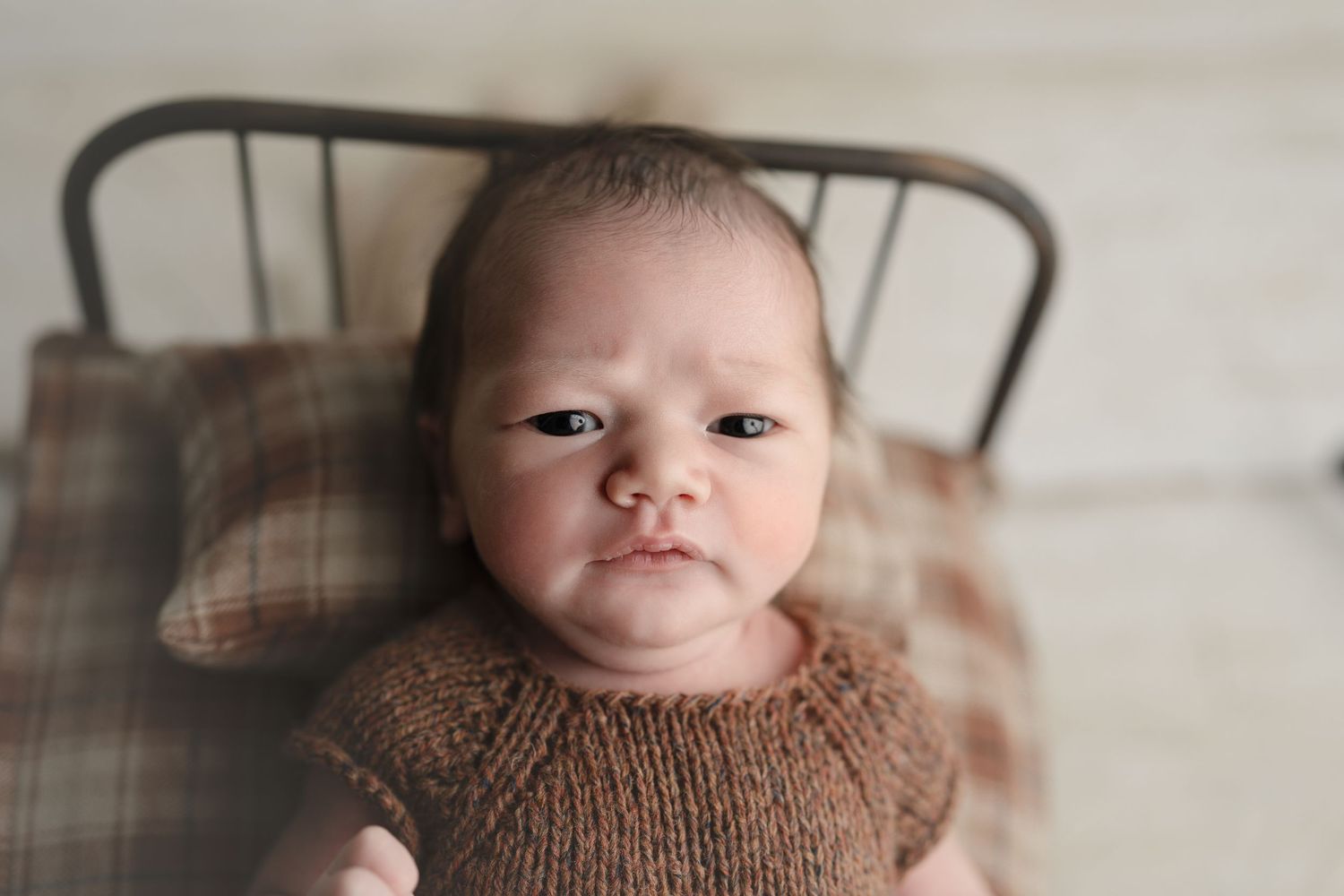Wide awake baby giving the camera a glare. Baby on green backdrop. Hatched Newborn and Family Photography. Madison, Monona, Verona