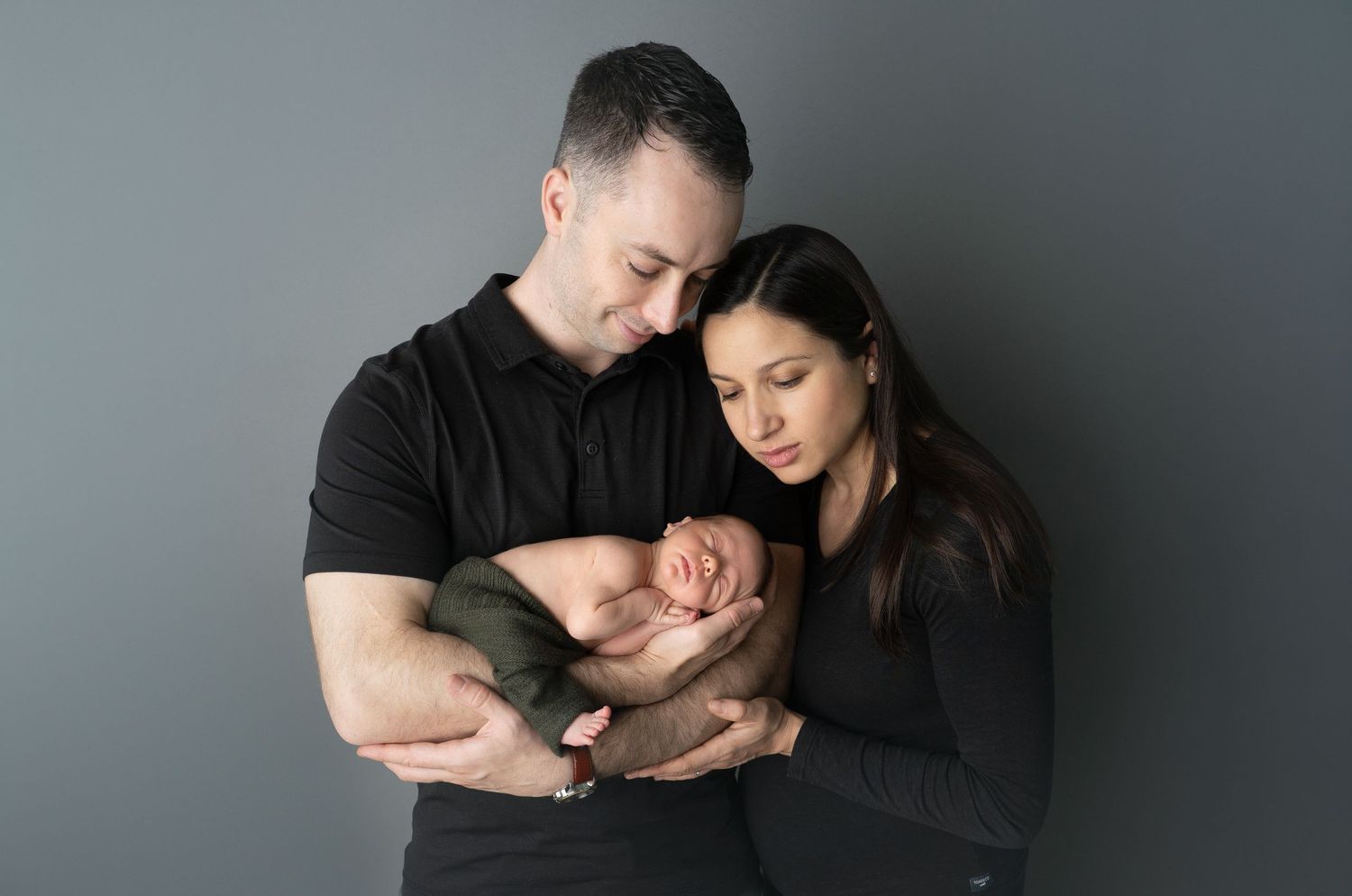 newborn snuggled in father's arms. Family newborn photos. Hatched newborn photography. Wisconsin's premiere newborn photography.