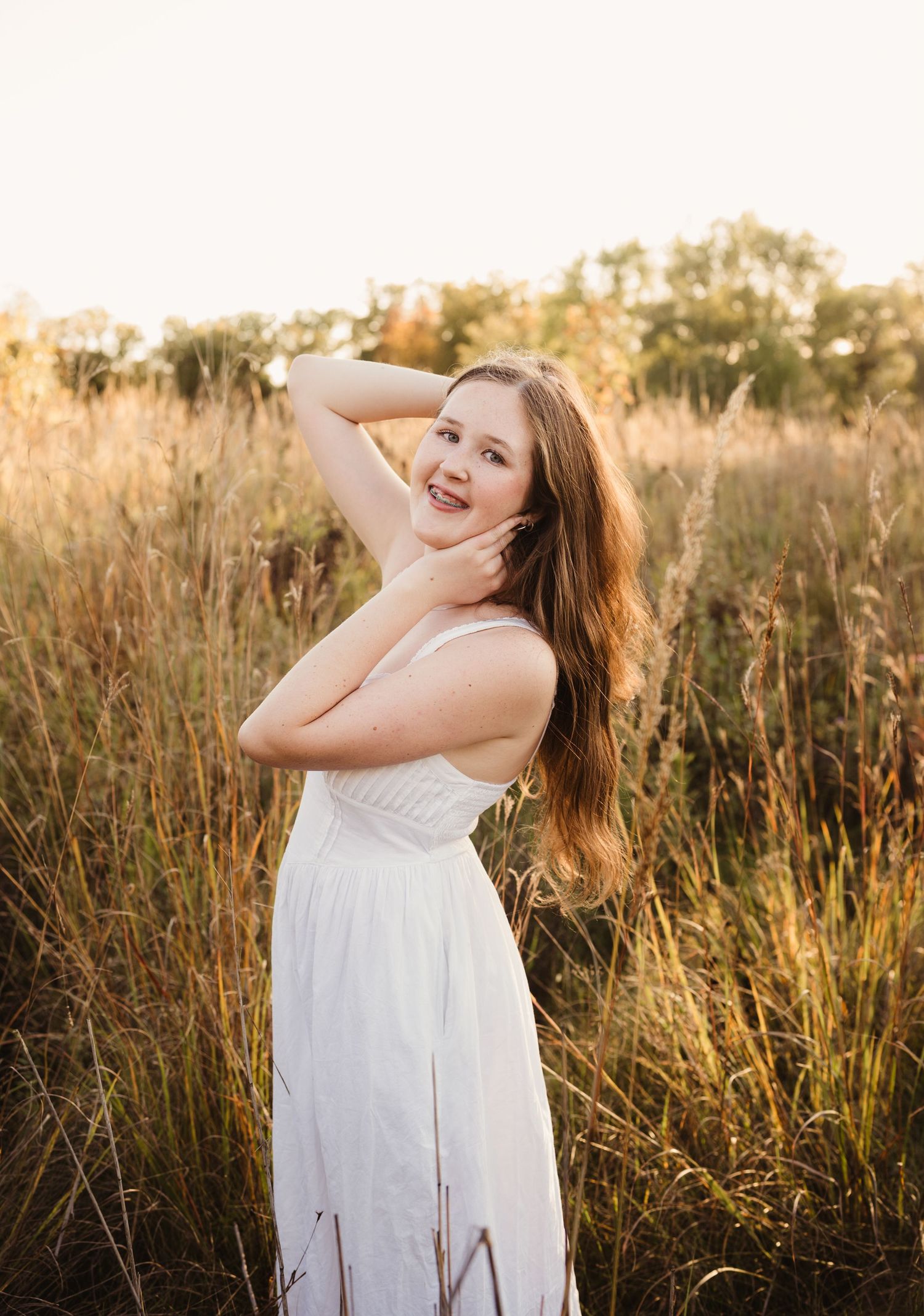 Beautiful senior photo of a girl in a field, golden hour photography