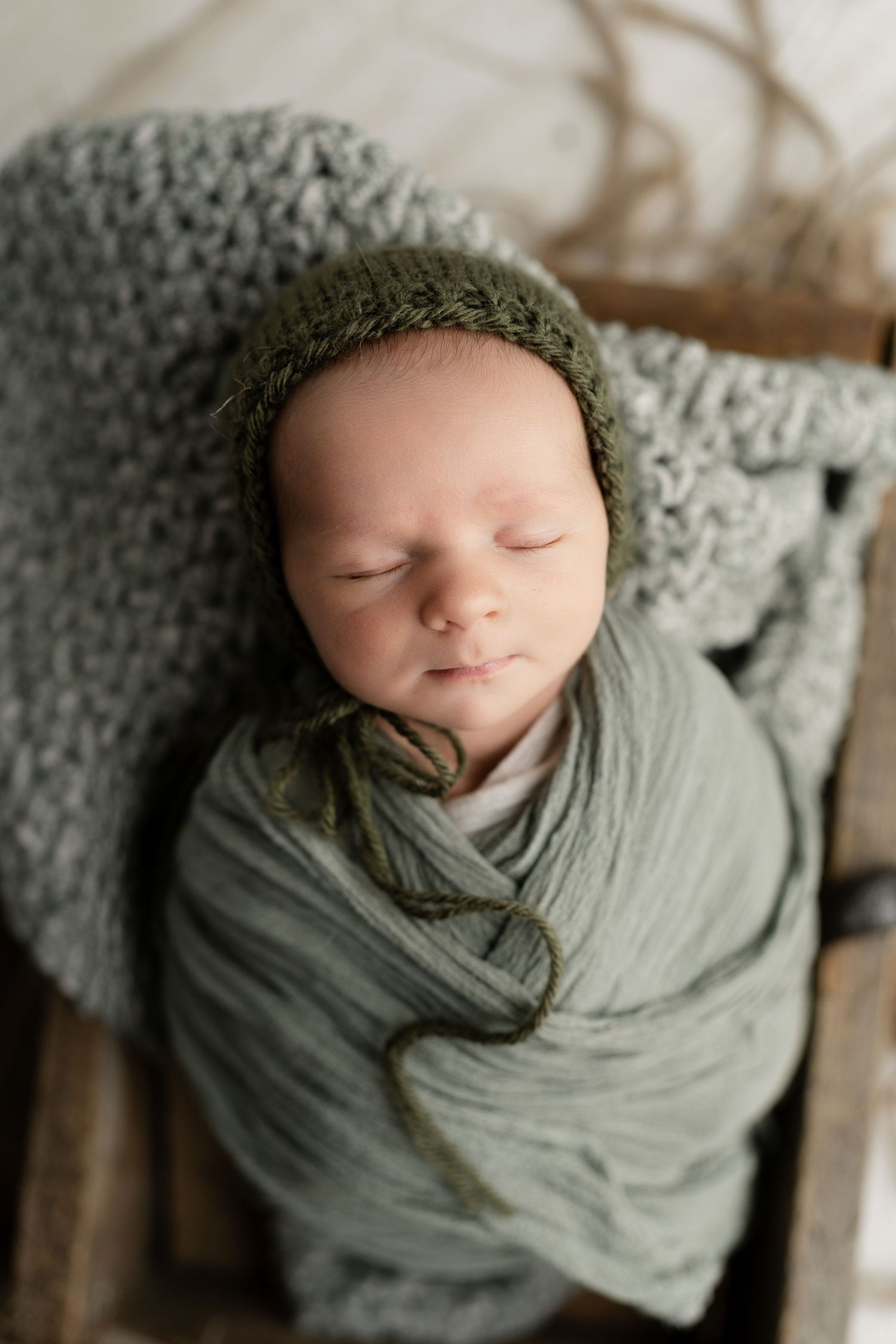 Baby snuggled soundly in wooden prop. Newborn photo. Hatched Newborns. Madison, Mount Horeb, Verona, Middleton, Wisconsin.
