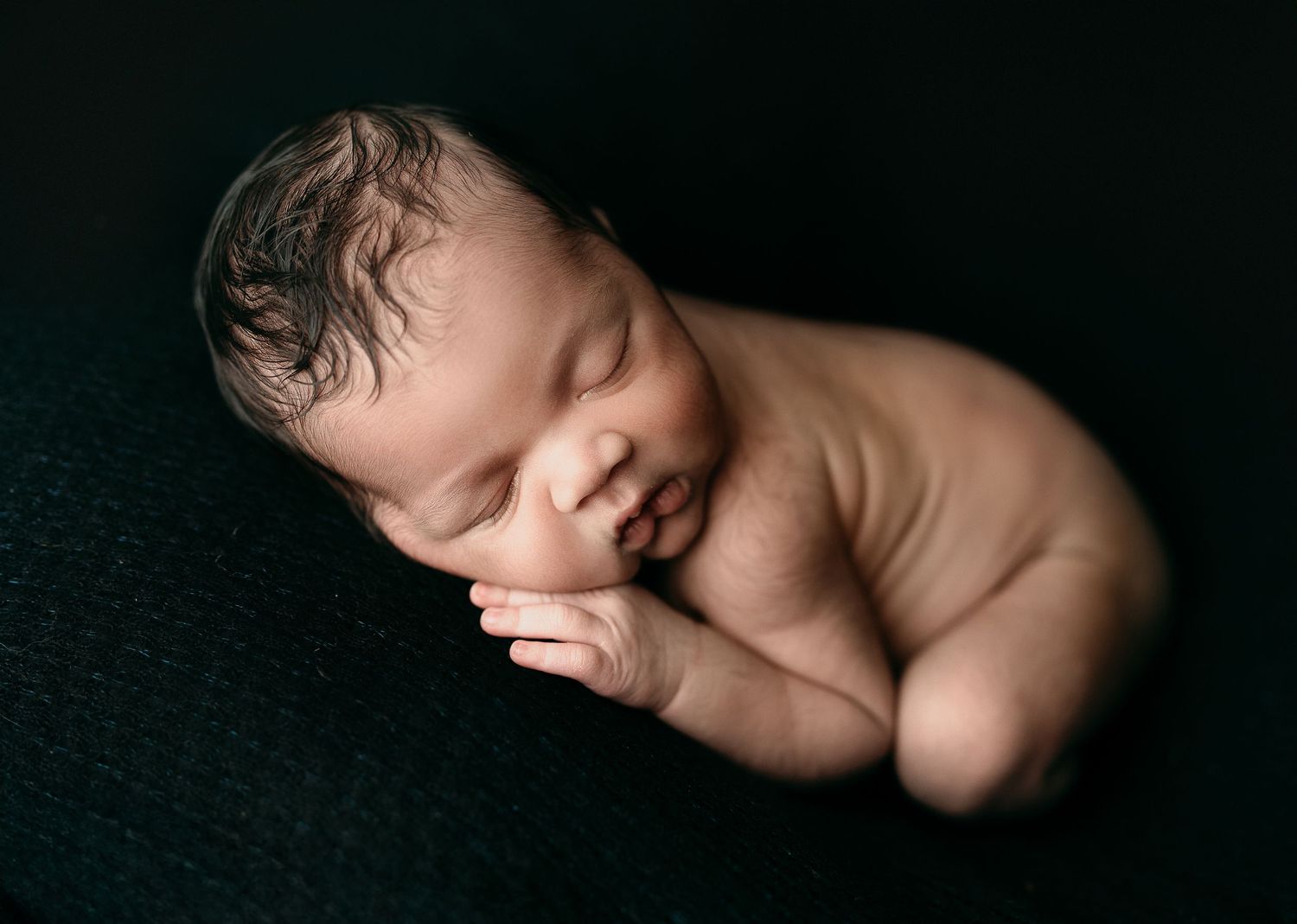 Dramatic black backdrop showcasing a cute baby. Maternity Photography by Hatched Photography, Serving Madison, Verona, Wisconsin