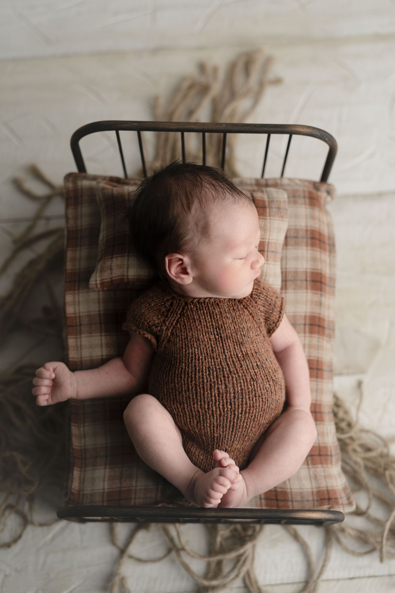 Baby on a tiny bed, taking a nap. Baby on green backdrop. Hatched Newborn and Family Photography. Madison, Monona, Verona, Mount Horeb, WI