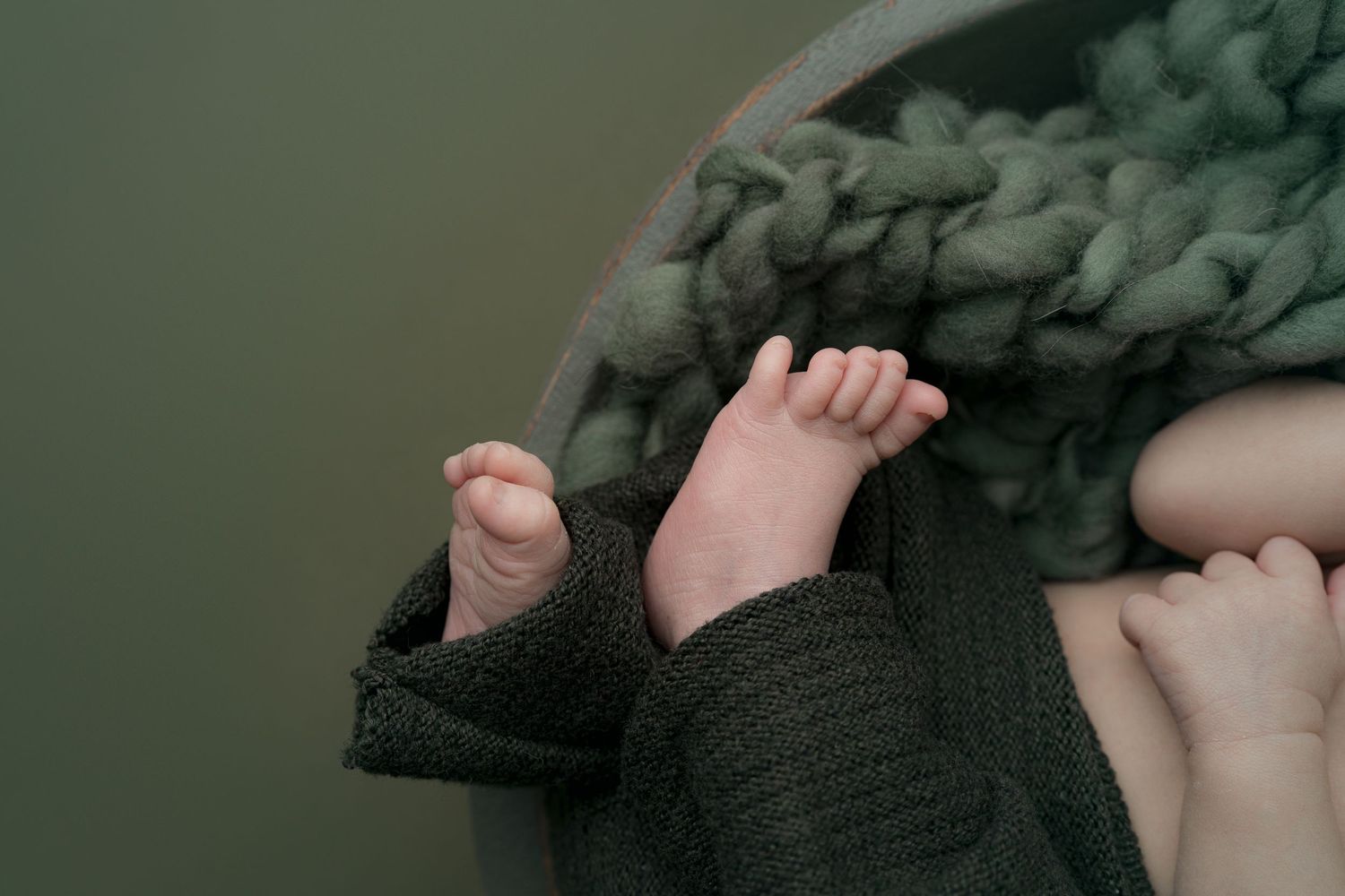 Newborn snuggled in green bowl. Hatched newborn photography. Wisconsin's premiere newborn and maternity photography.