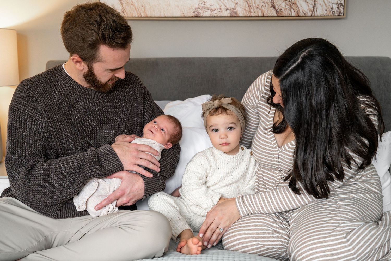A series of five cozy family photos showing tender moments of parents and children relaxing together on a bed.
