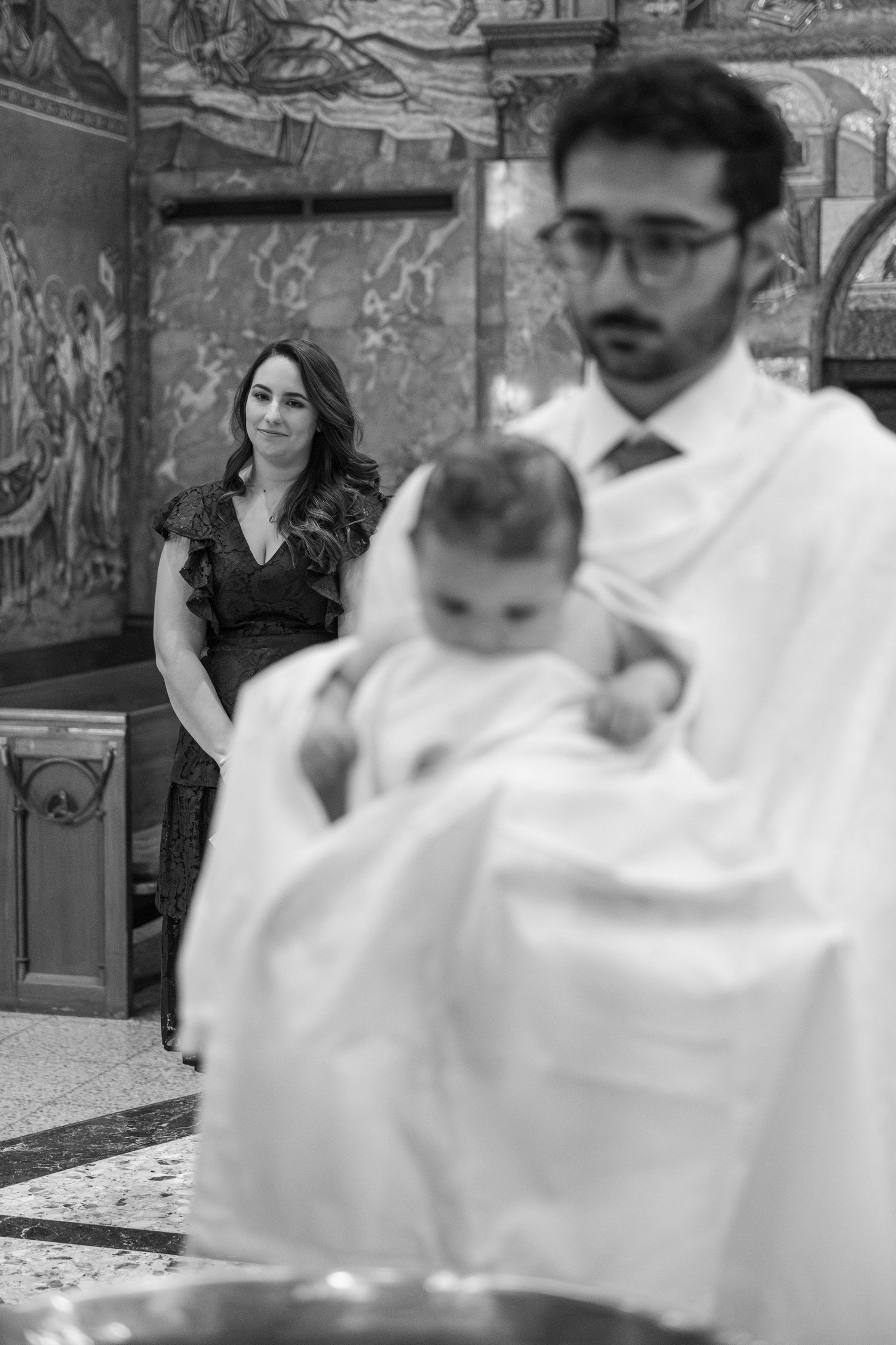 A baptismal ceremony sequence showing the traditional blessing of an infant in a church setting.