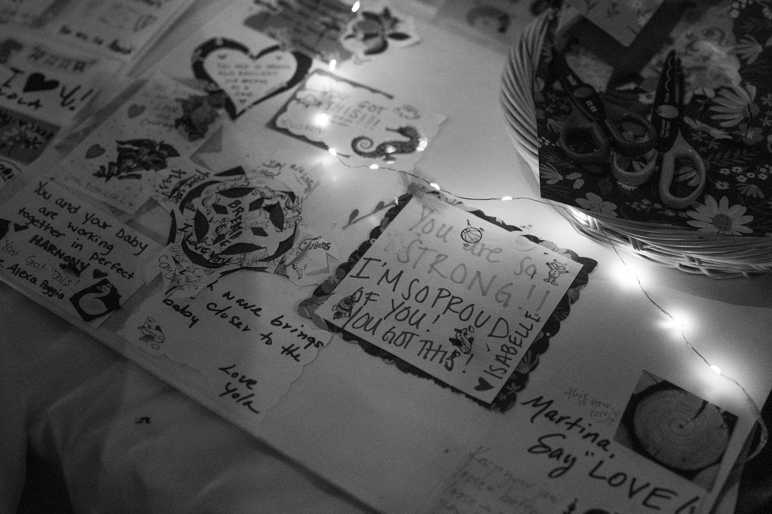 Handwritten notes and sketches illuminated by string lights on paper.