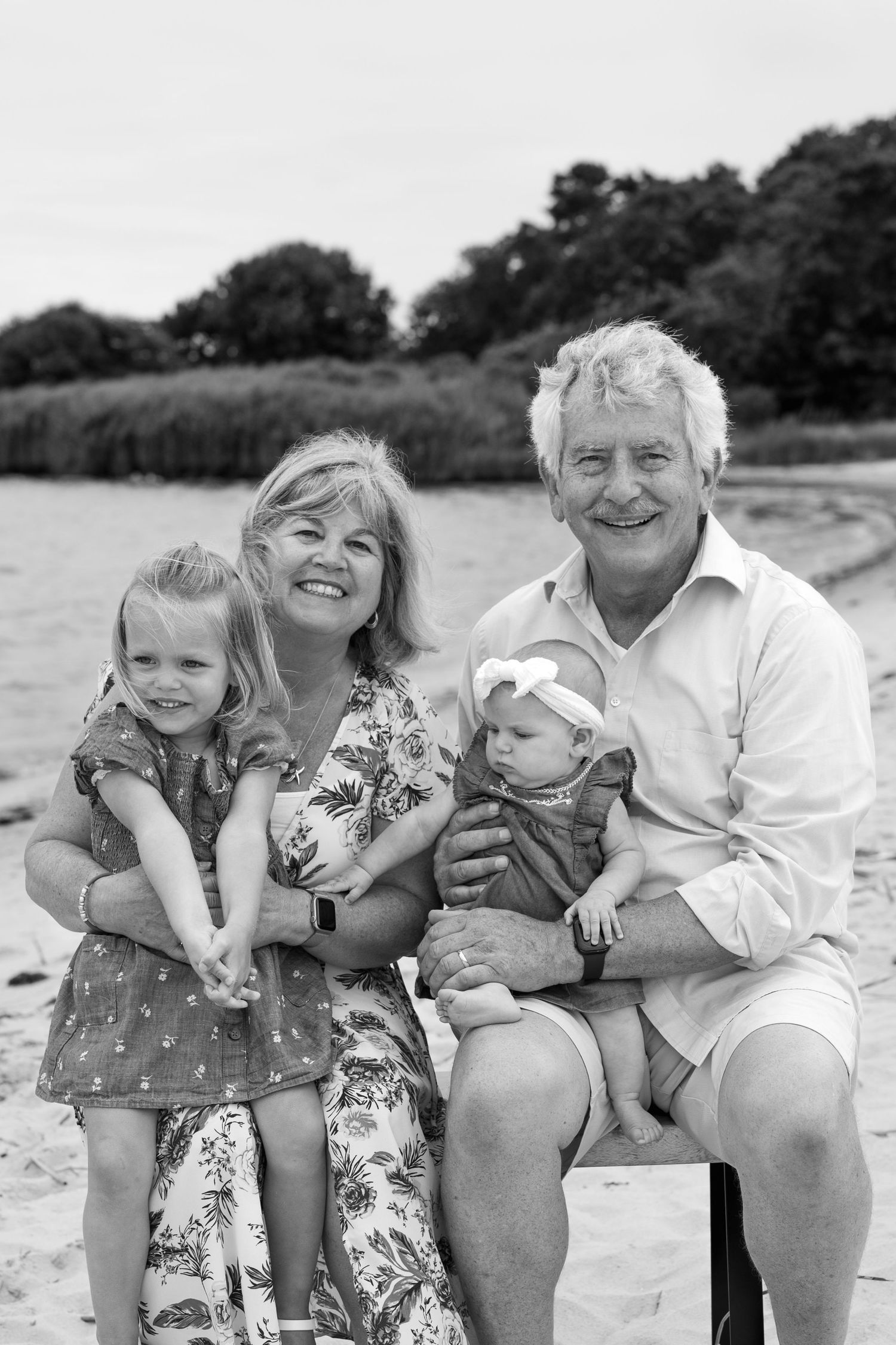 Family moment captured on beach in black and white.