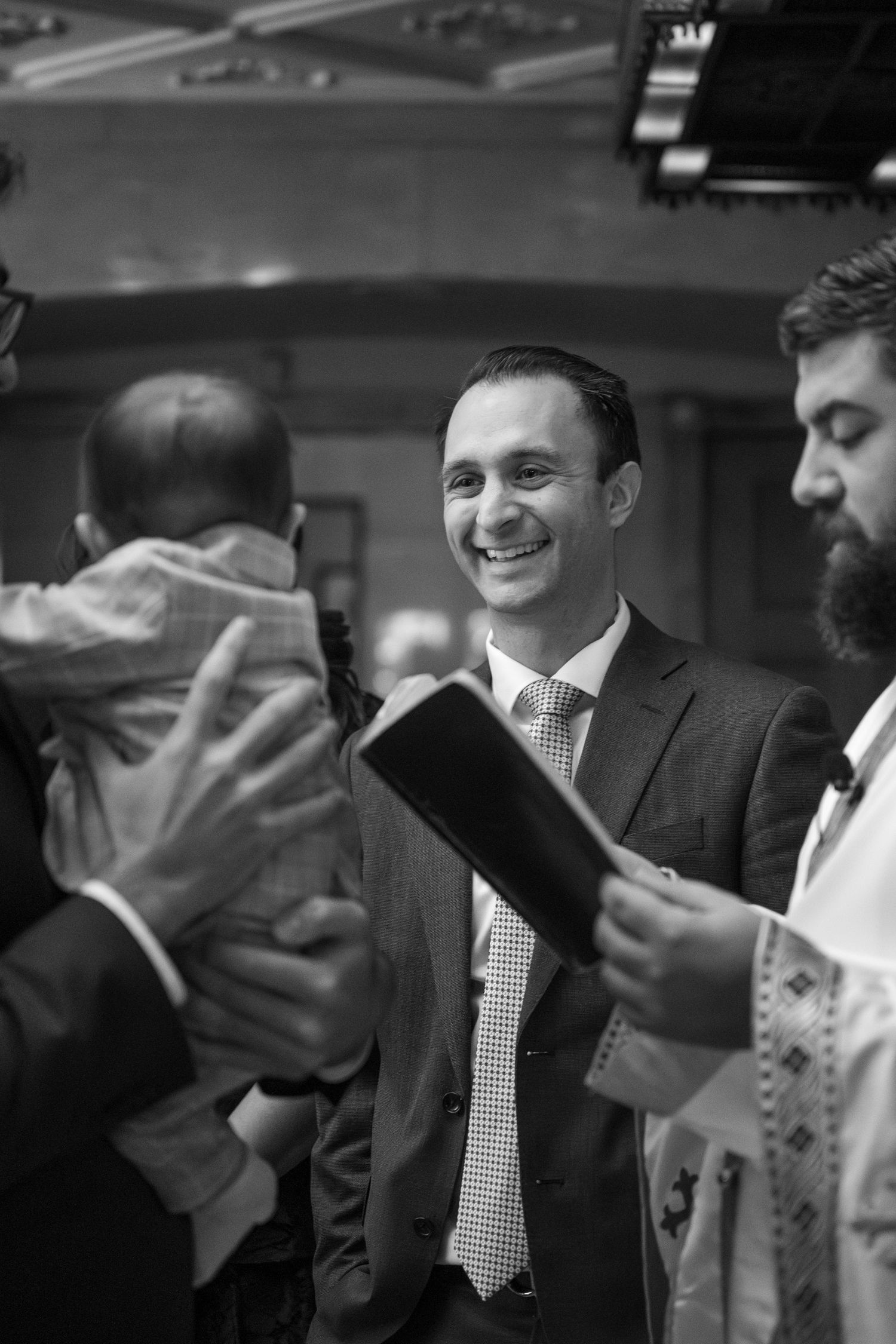 Black and white sequence of people celebrating during a Jewish religious ceremony in an indoor setting.