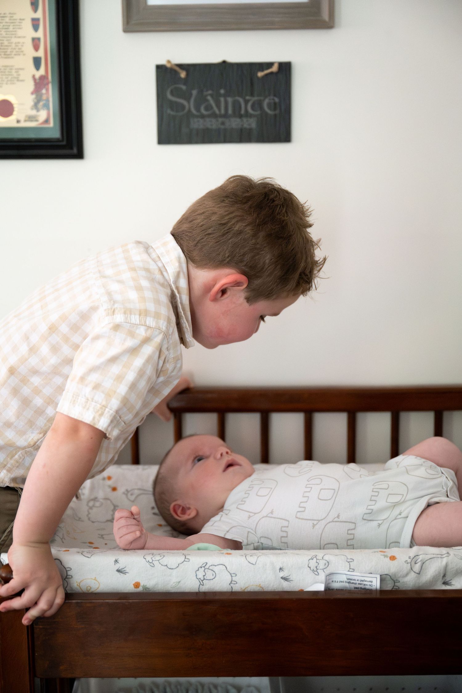 A series of tender moments showing interaction with a baby lying on a wooden crib.