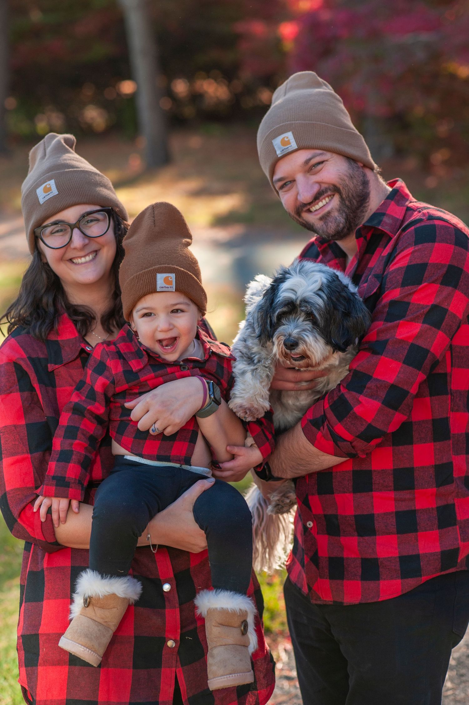 Family photo series with dog showing group hugs and laughter while wearing coordinated buffalo plaid outfits.