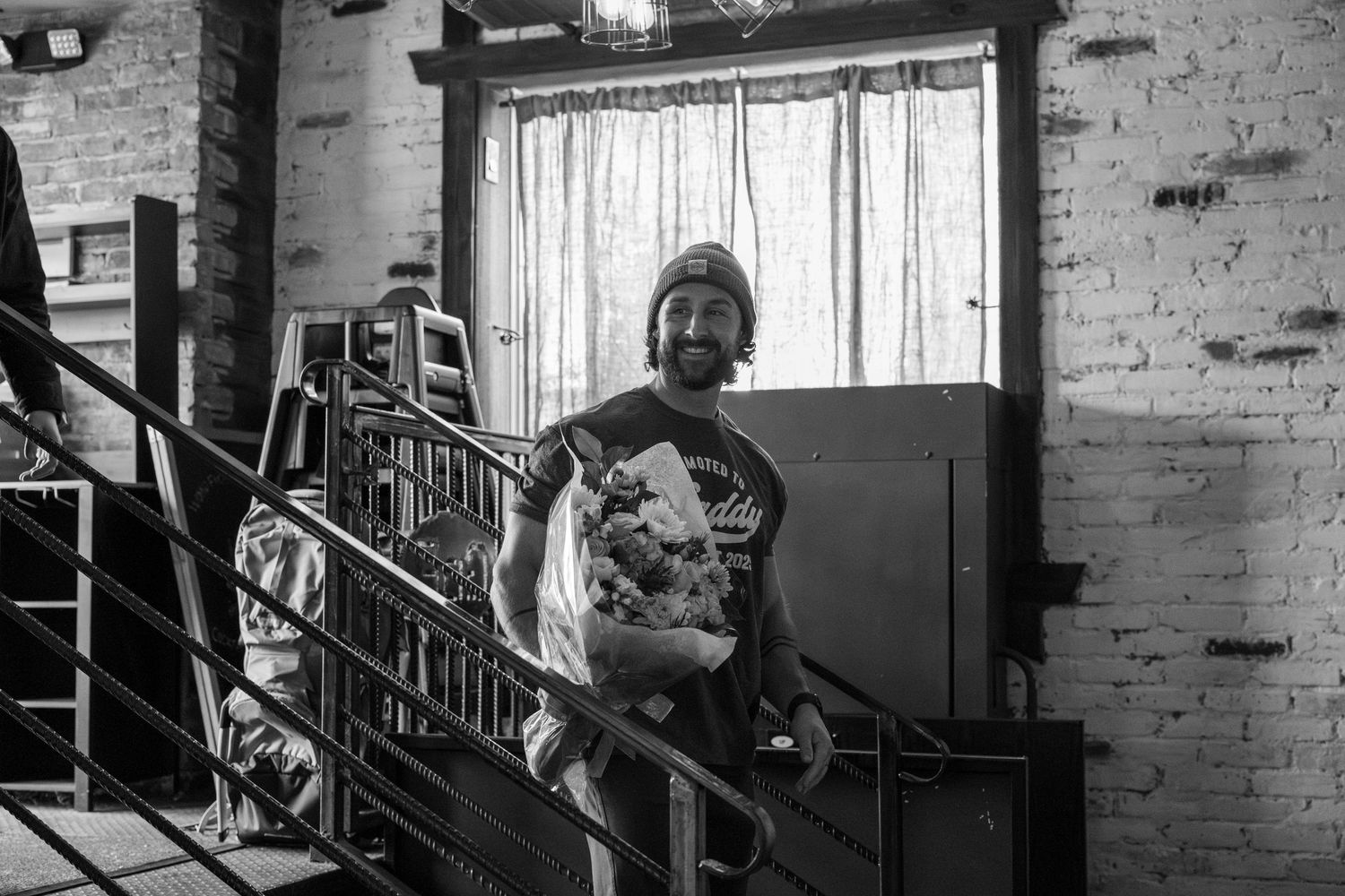 Black and white photos showing interior scenes with exposed brick walls and natural lighting.