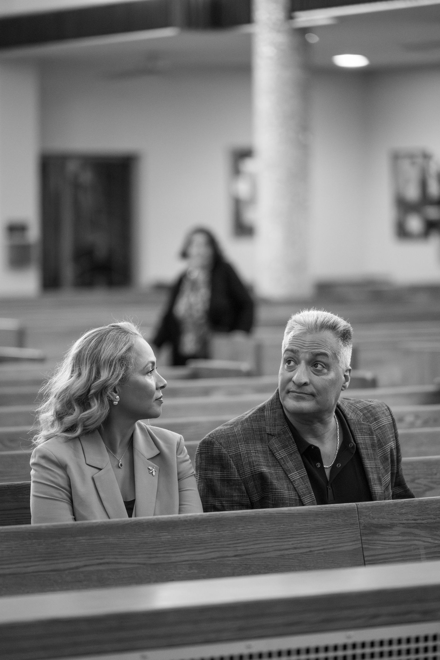 A black and white photo sequence shows two people sitting in church pews having an animated conversation.