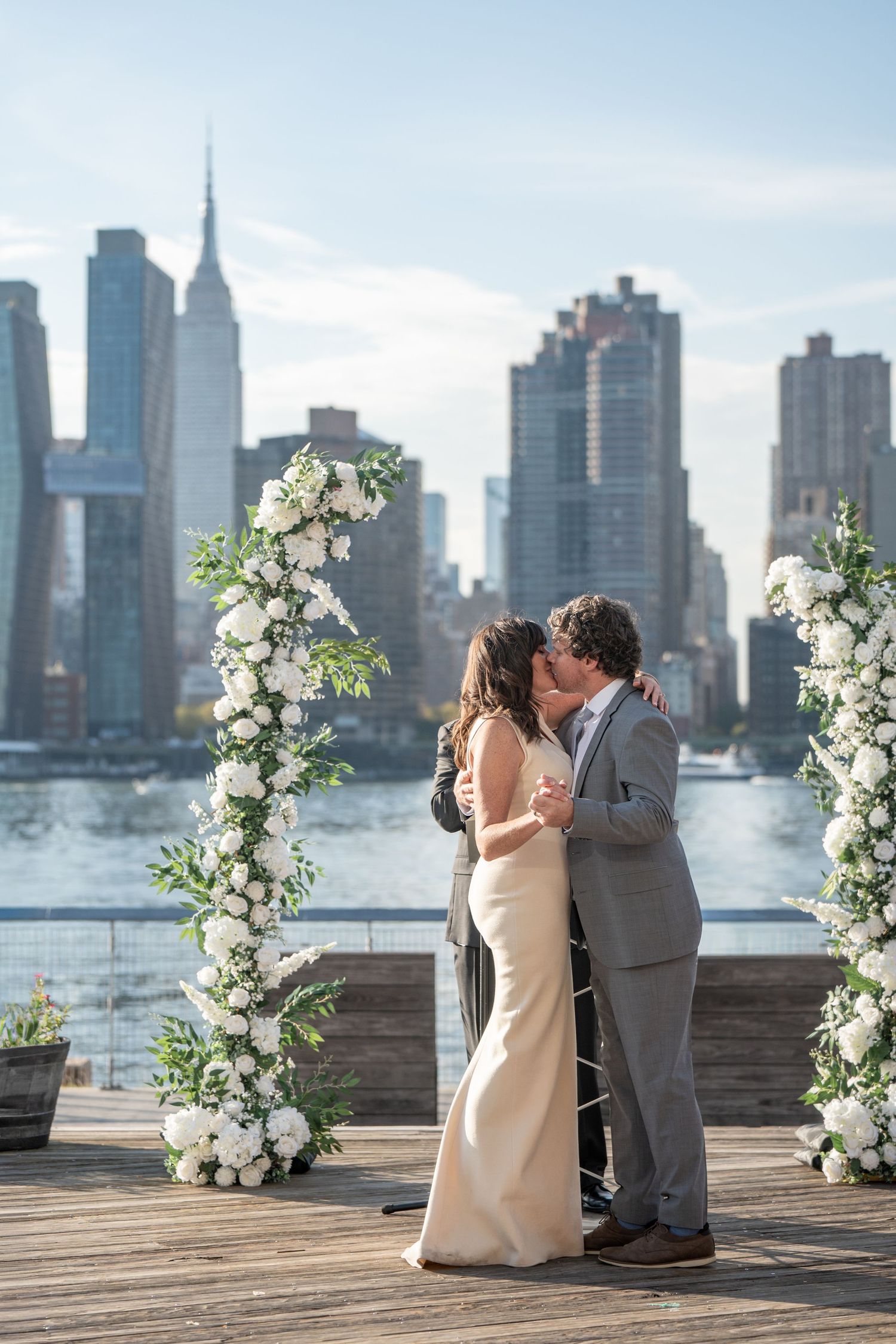 A romantic wedding ceremony on a waterfront deck with the New York City skyline as a stunning backdrop.
