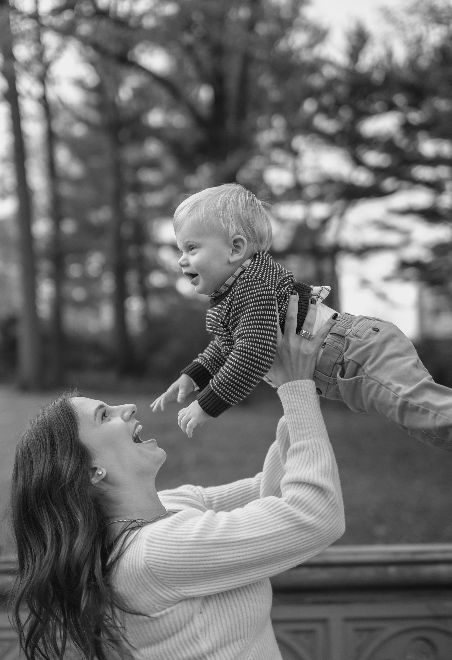 Black and white series capturing playful moments between parent and baby outdoors.
