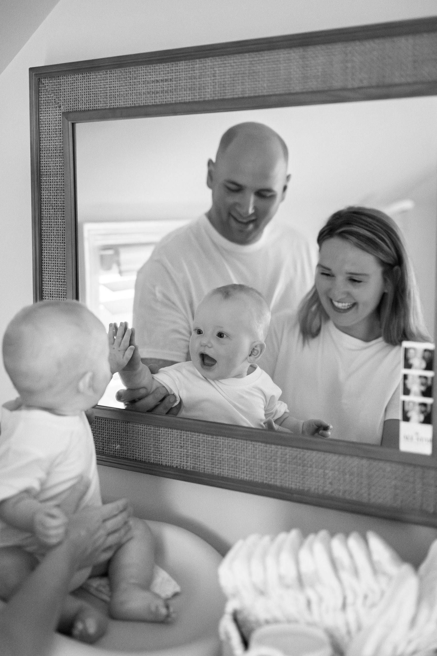 Series of intimate black and white photos showing joyful family interactions reflected in a mirror.