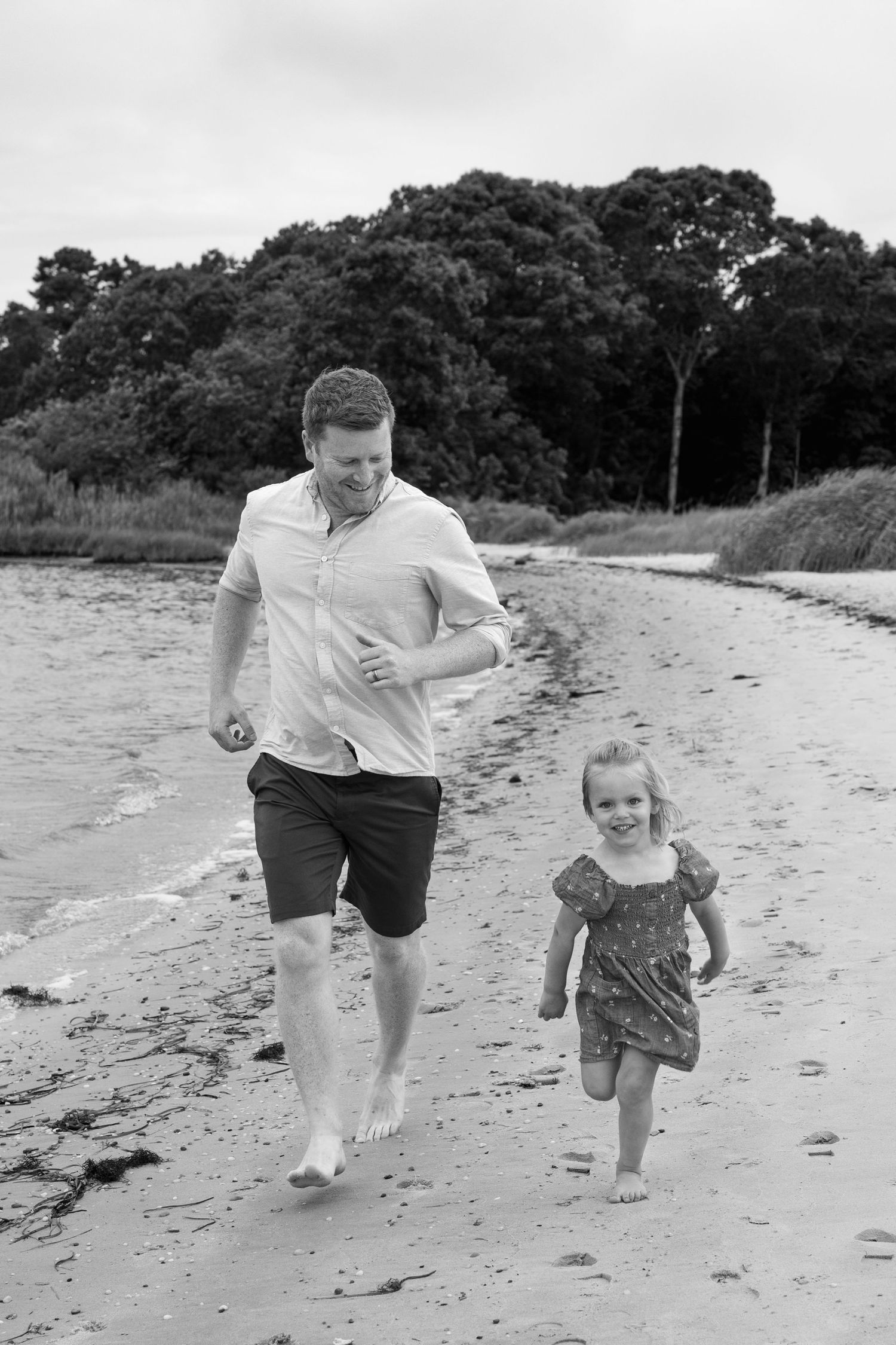 Black and white photos of a family running and playing together on a beach.