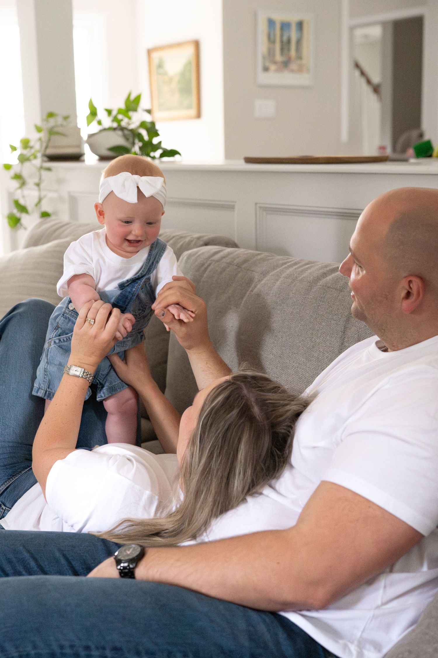 Candid family moments on a gray couch showing playful interaction and laughter.