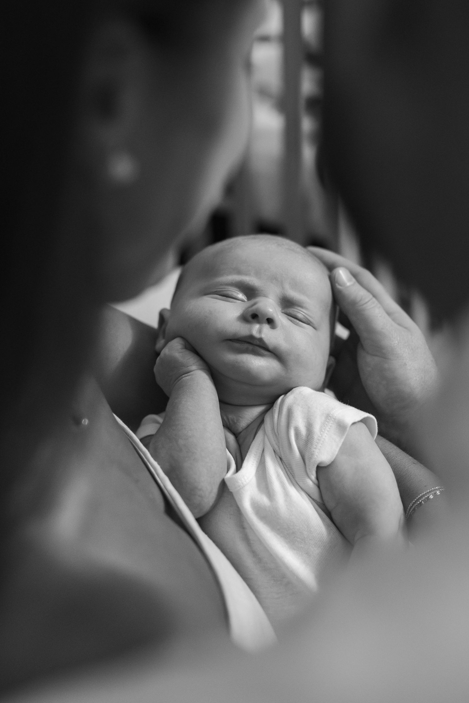 Peaceful sleeping newborn baby in black and white portrait series.