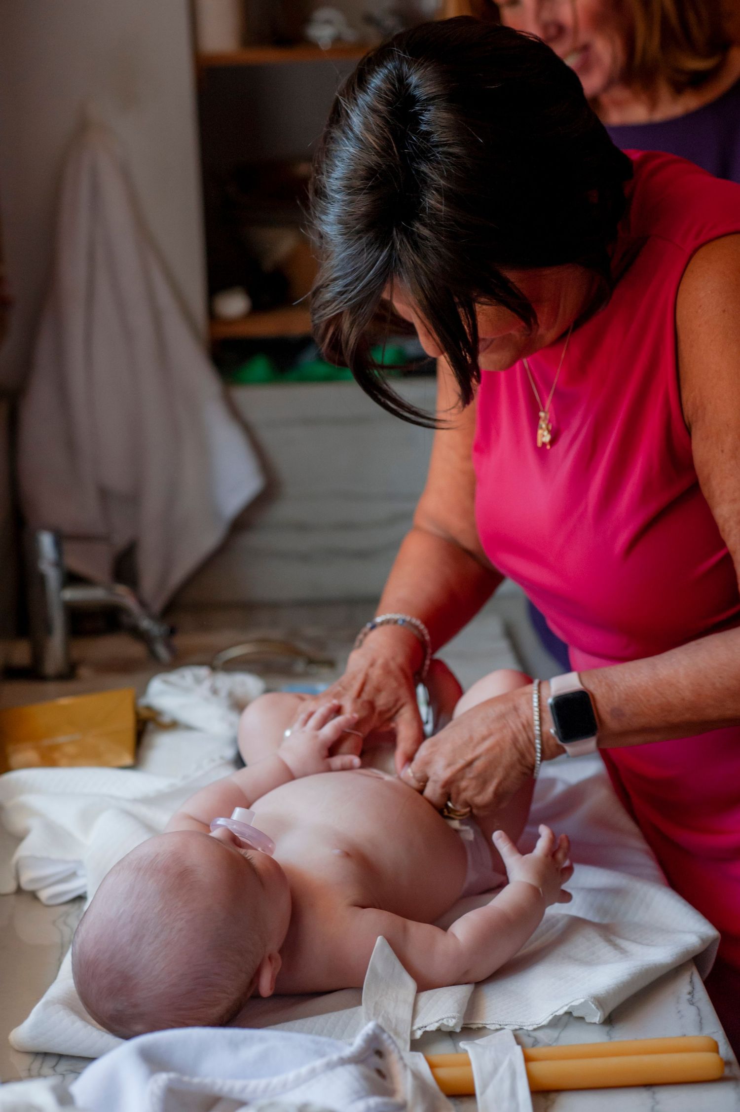 A baby receiving a gentle massage while lying on a white towel.