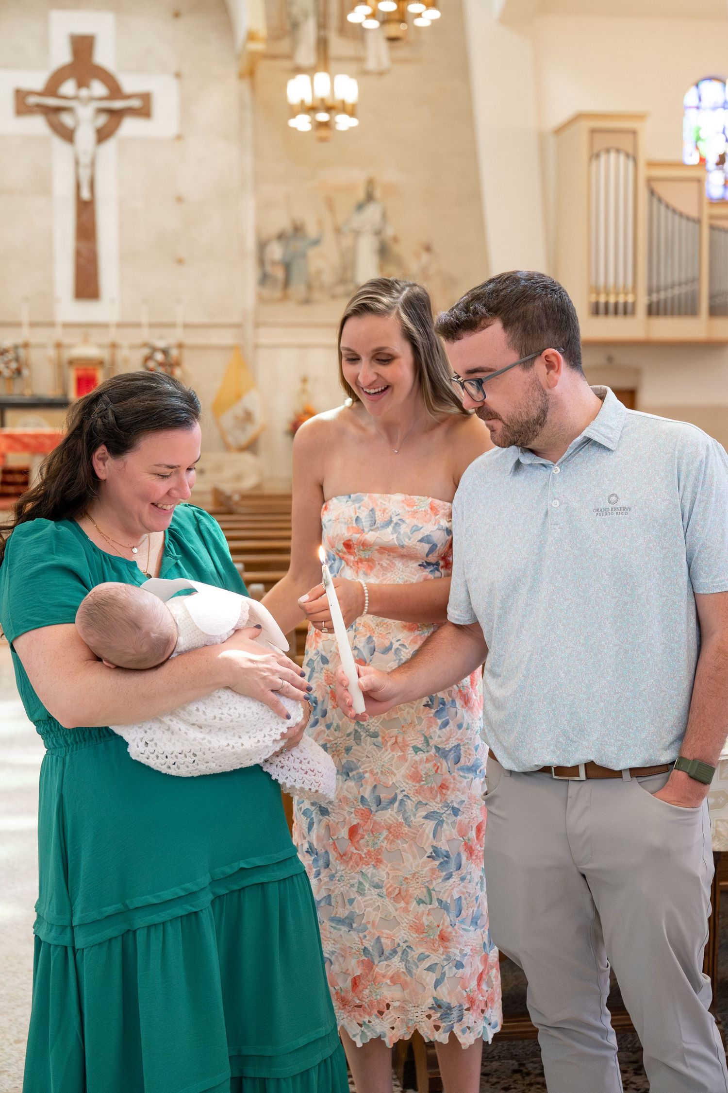 A baptism ceremony taking place inside a church with religious artwork and an organ visible.