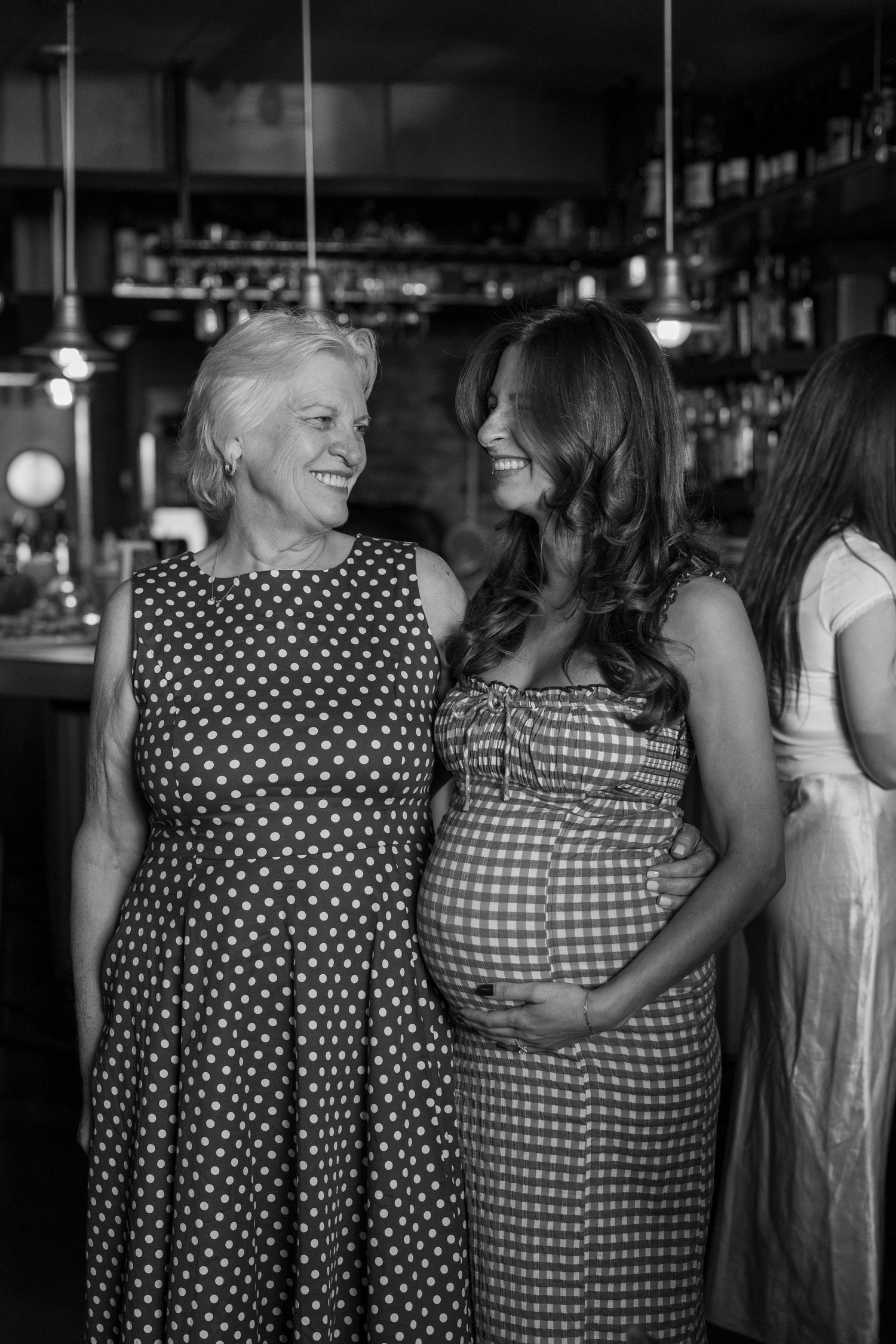 Two people in polka dot dresses sharing a joyful moment at a party.