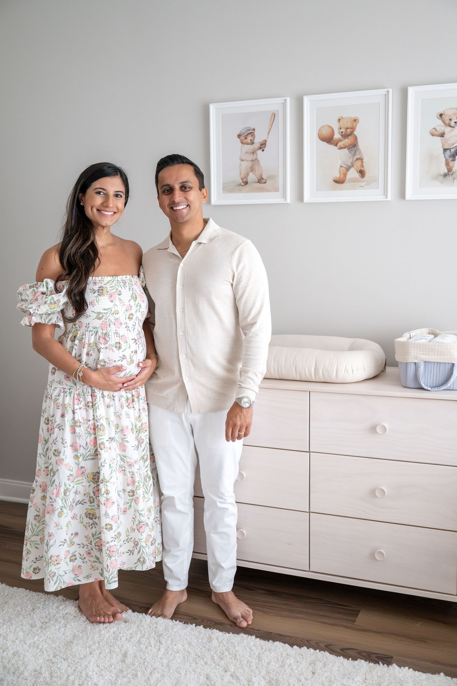 Maternity photo session in nursery with white furniture and teddy bear artwork.