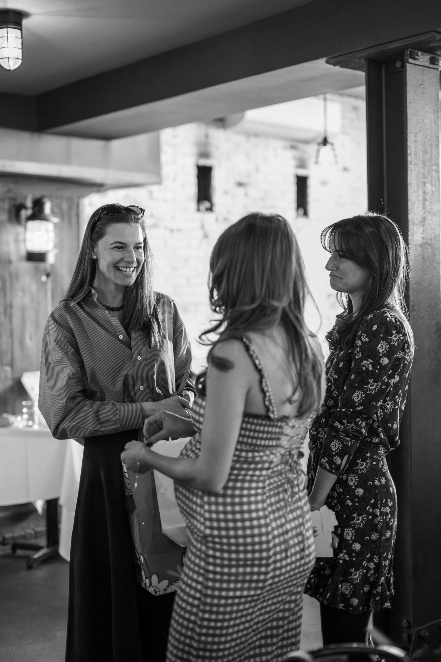 A group of guests sharing laughter and conversation at an indoor social gathering.