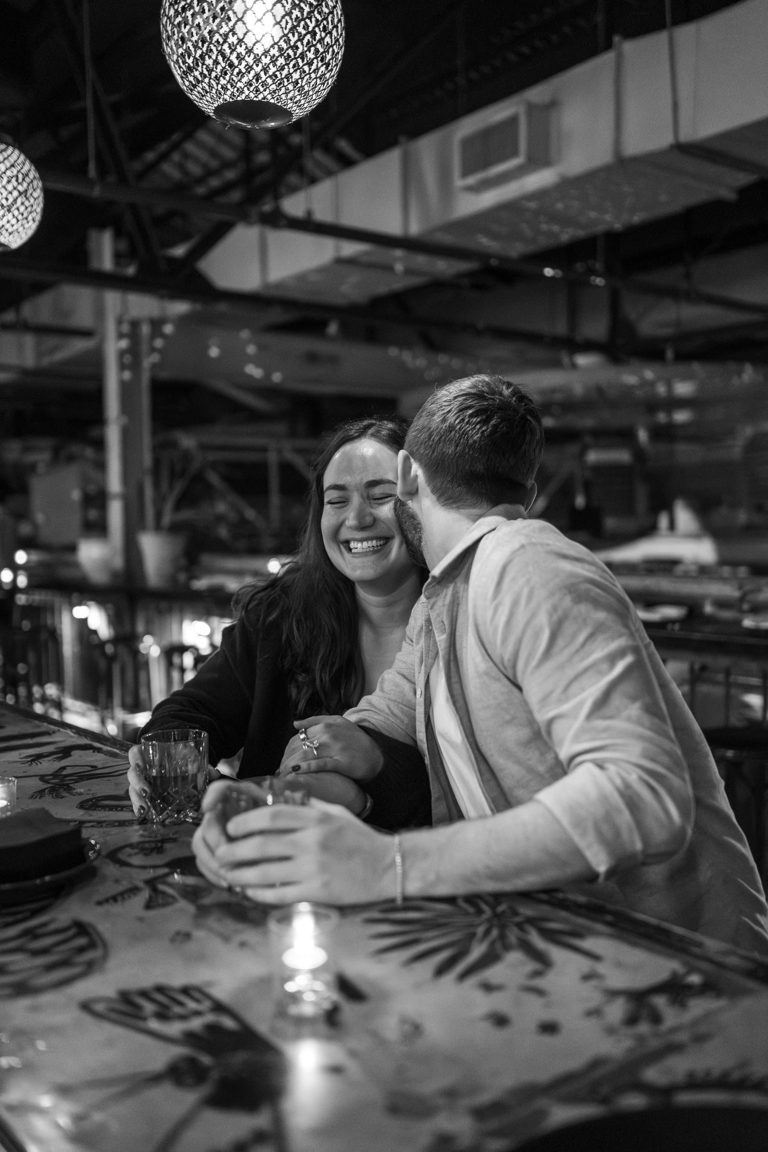 Black and white sequence of candid moments at a restaurant table with disco ball lighting overhead.