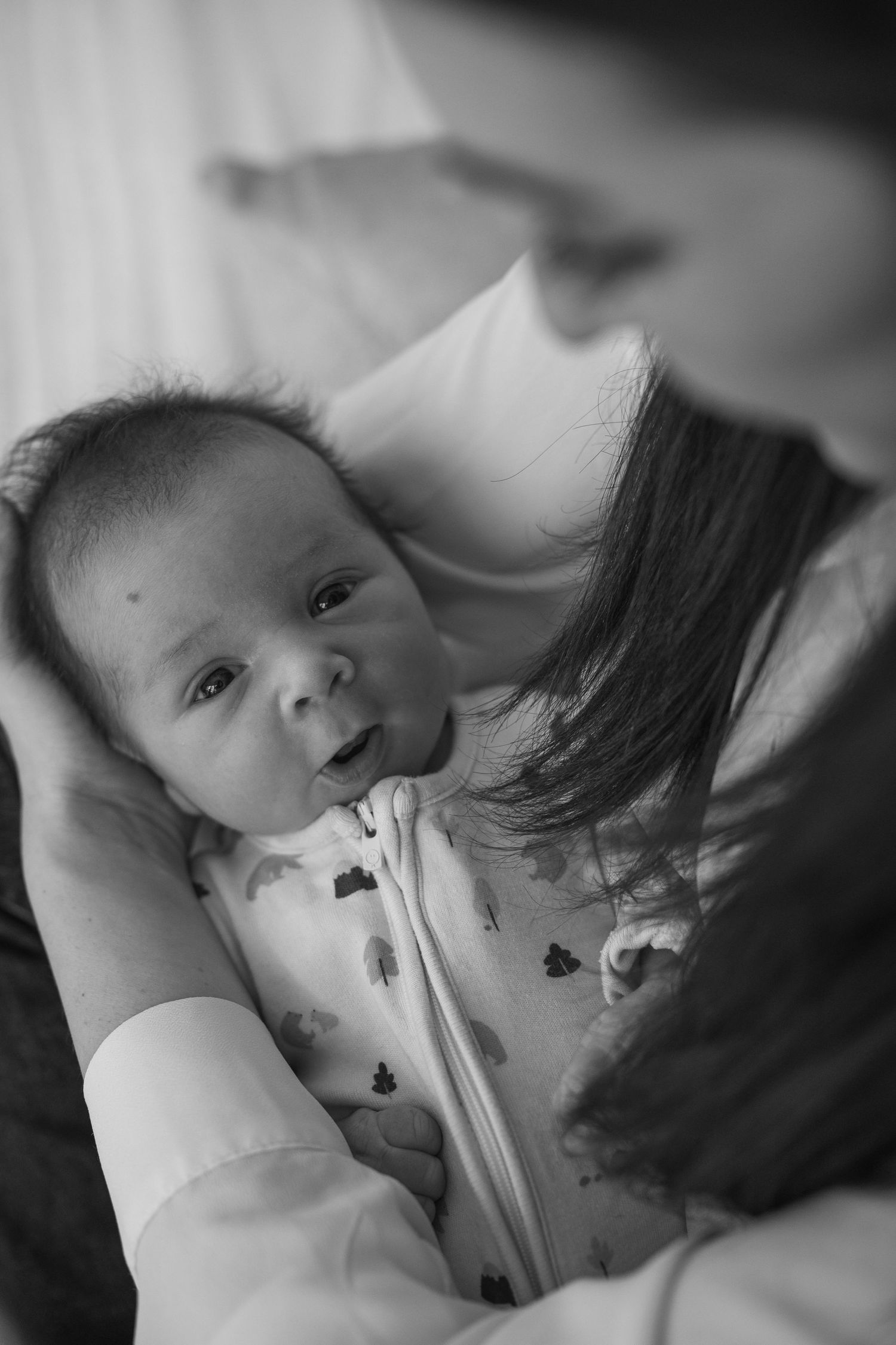 Black and white close-up photos of a newborn baby with medical tubes.