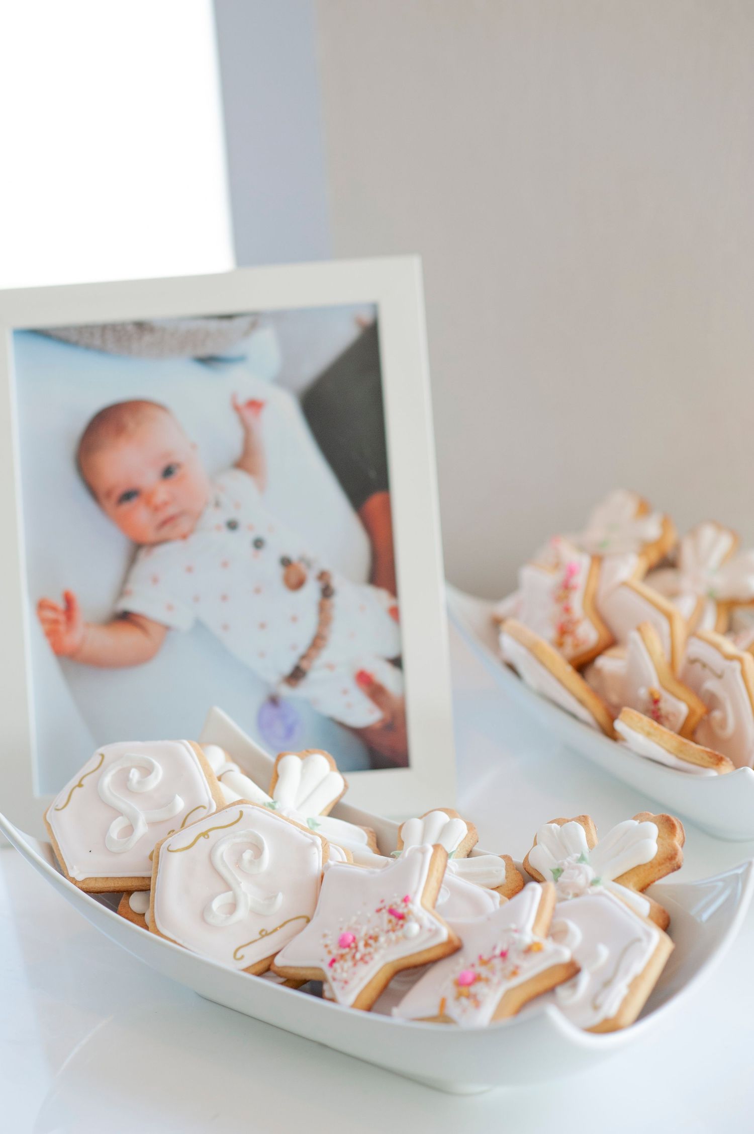 Decorative white frosted cookies displayed on a white surface.