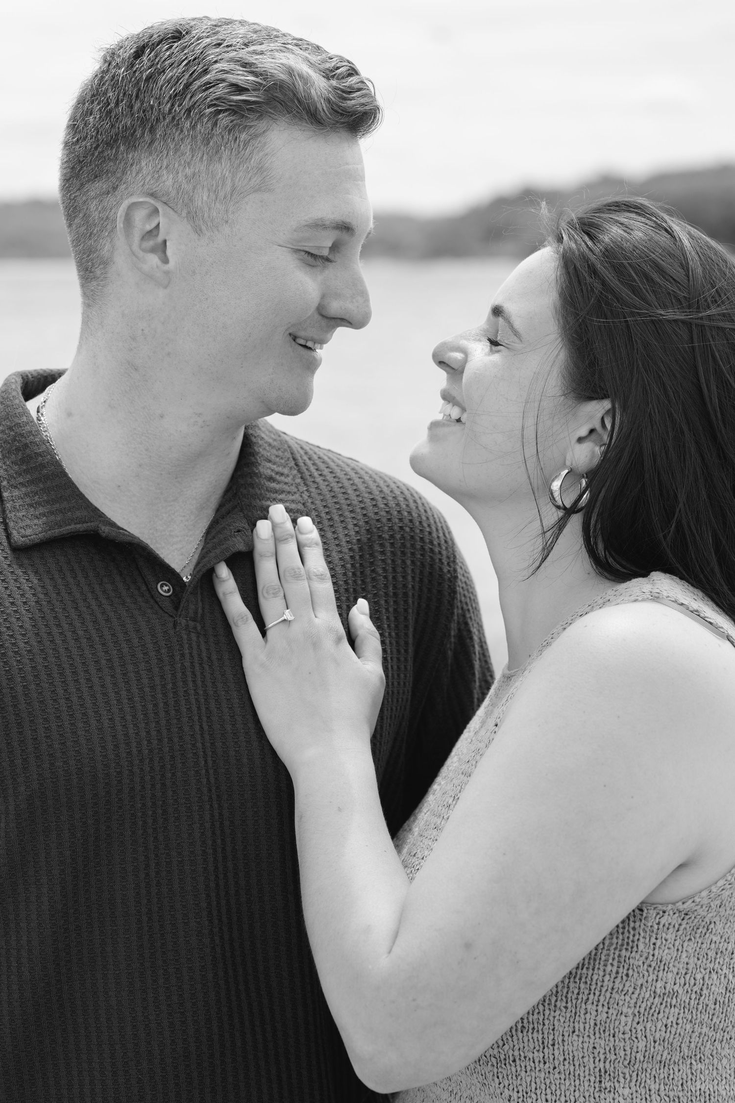 A romantic couple in black and white sharing intimate moments outdoors.